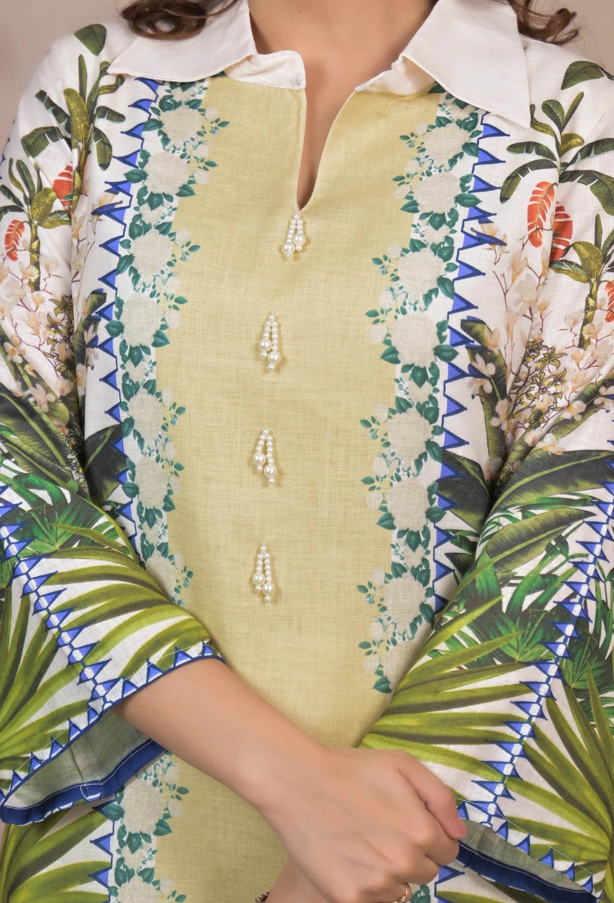 Close-up of a person wearing a green floral-patterned outfit with a white collar.