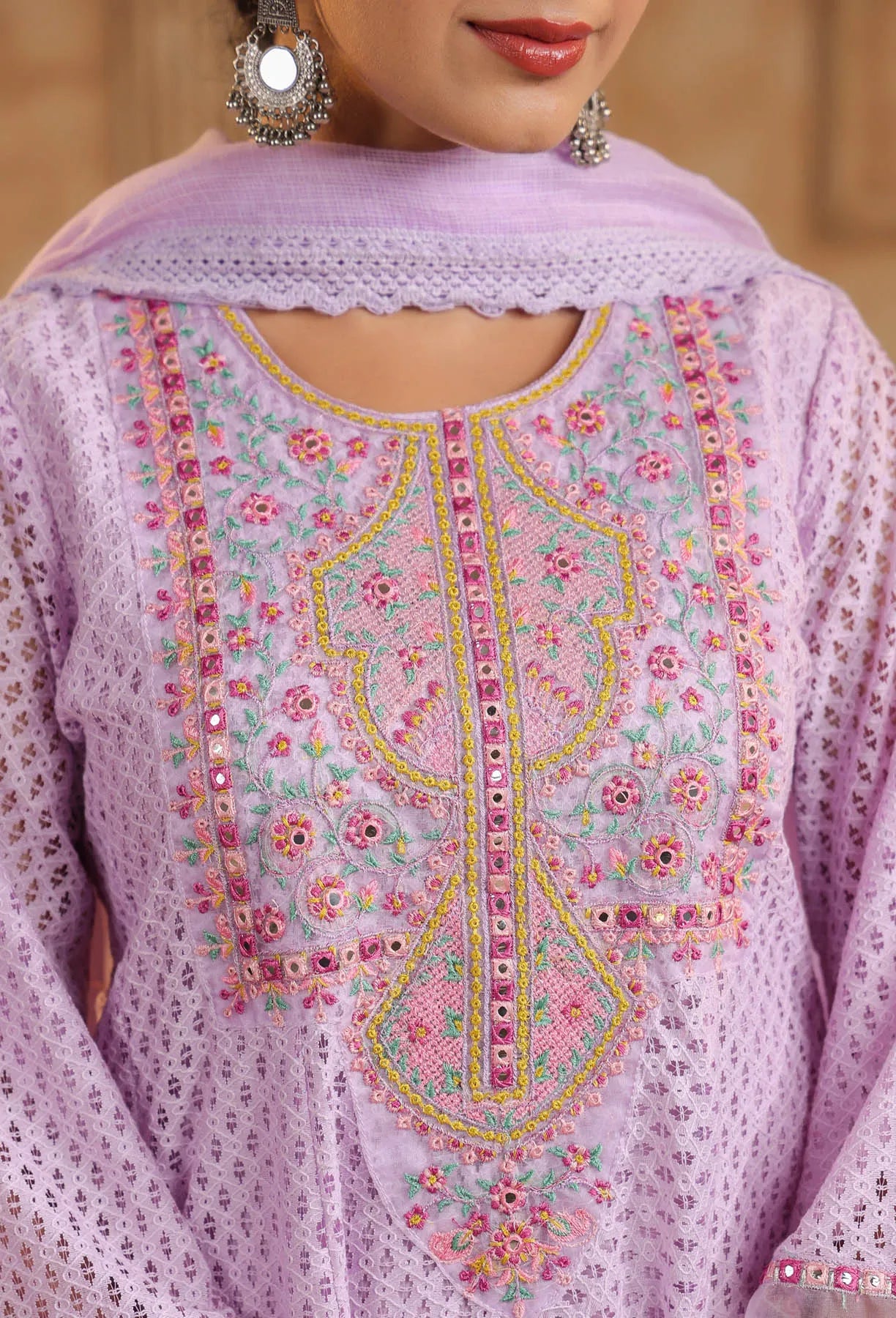 Close-up of a lavender embroidered garment with floral patterns.