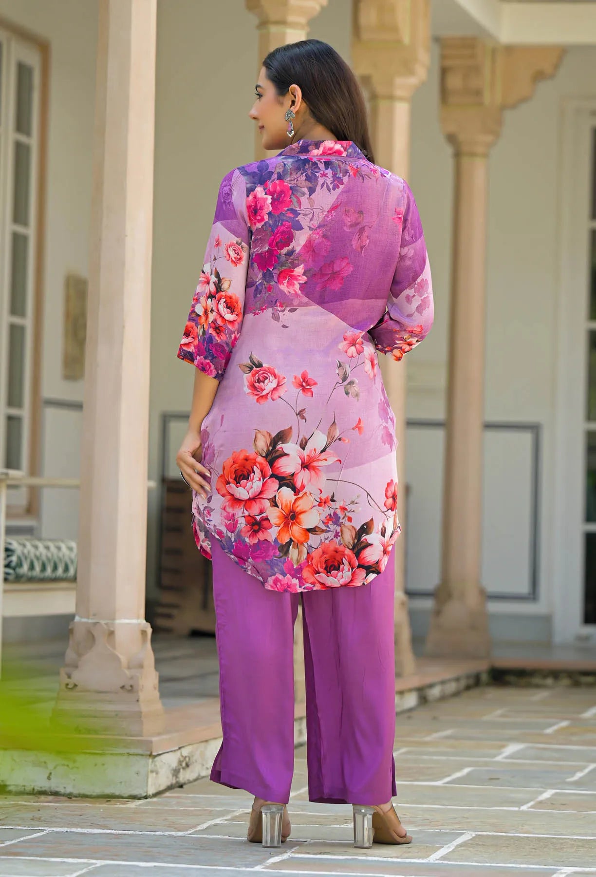 Woman wearing a vibrant floral dress with a purple background