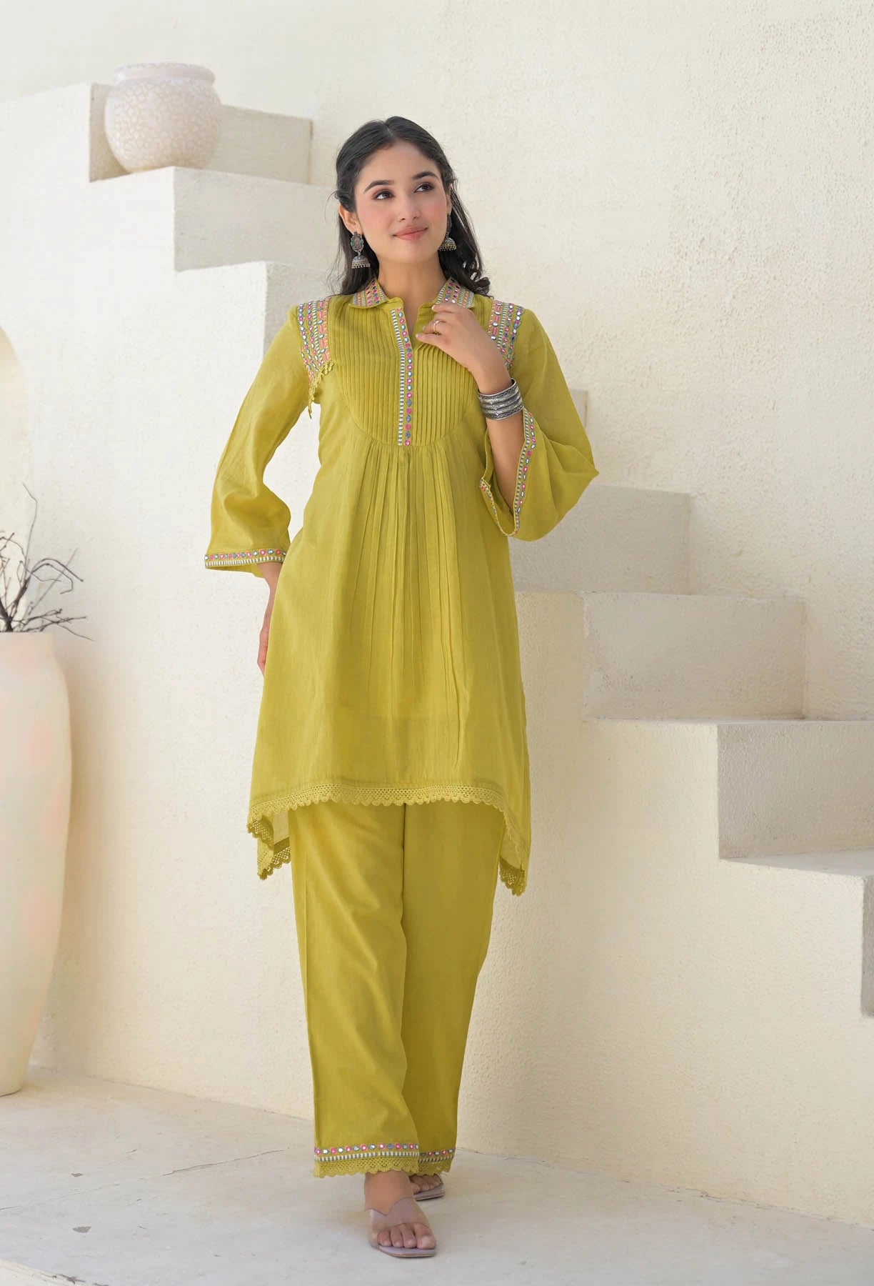 Woman wearing a yellow traditional outfit with a white background