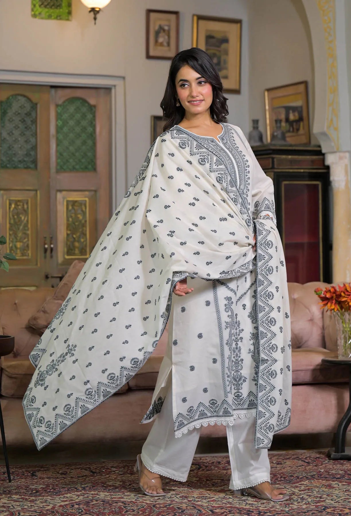 Woman in a traditional outfit standing in a living room.