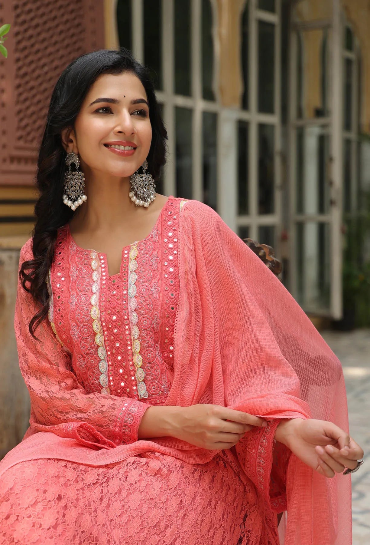 Woman in a pink traditional outfit with a blurred background