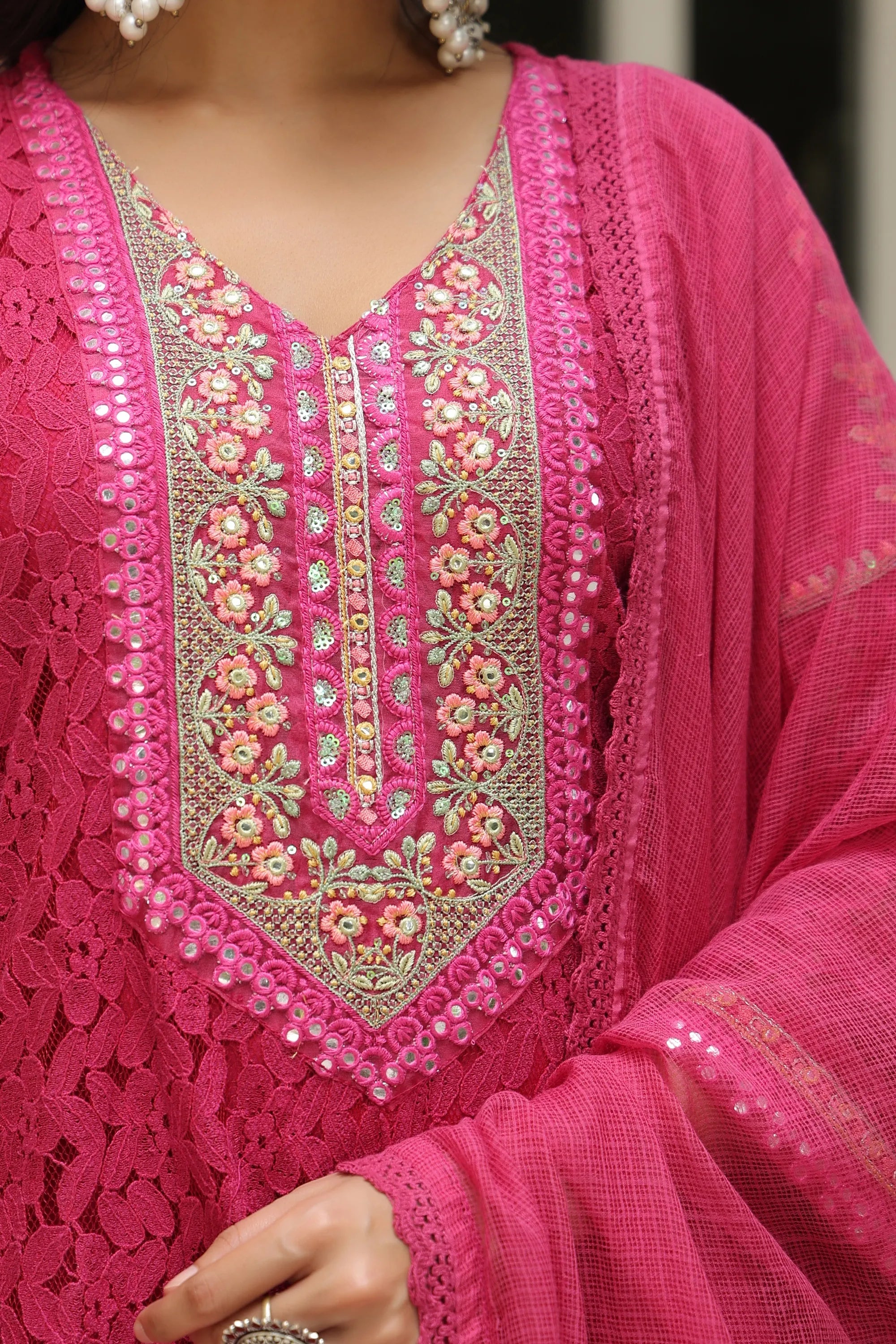 Close-up of a pink embroidered traditional outfit with intricate designs.
