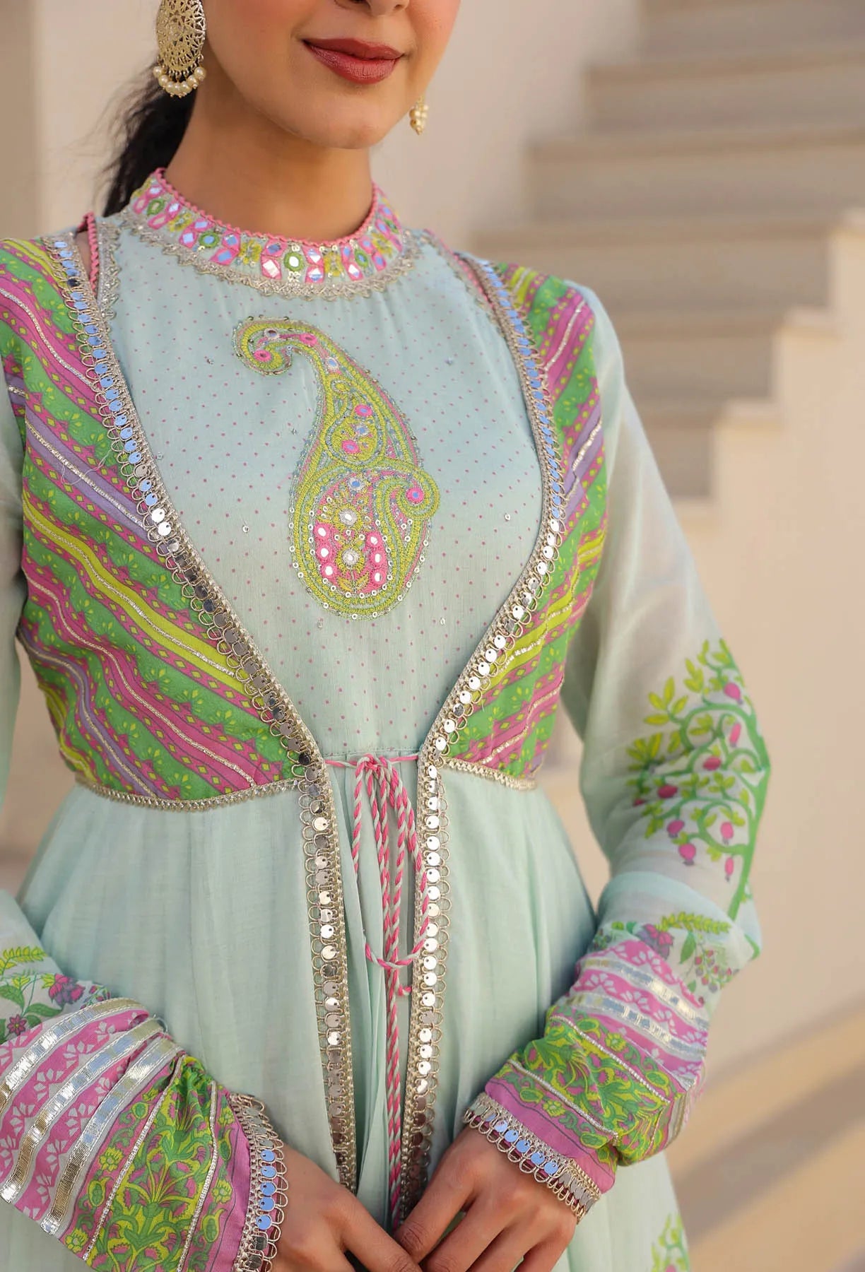 Light blue embroidered outfit with colorful patterns on a blurred background