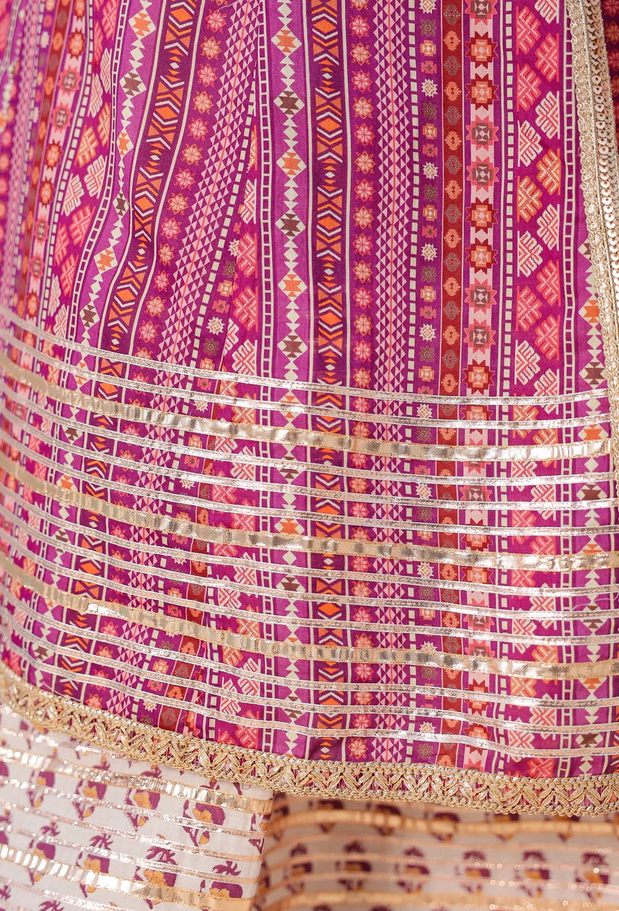 Close-up of a vibrant, patterned fabric with pink and purple hues.