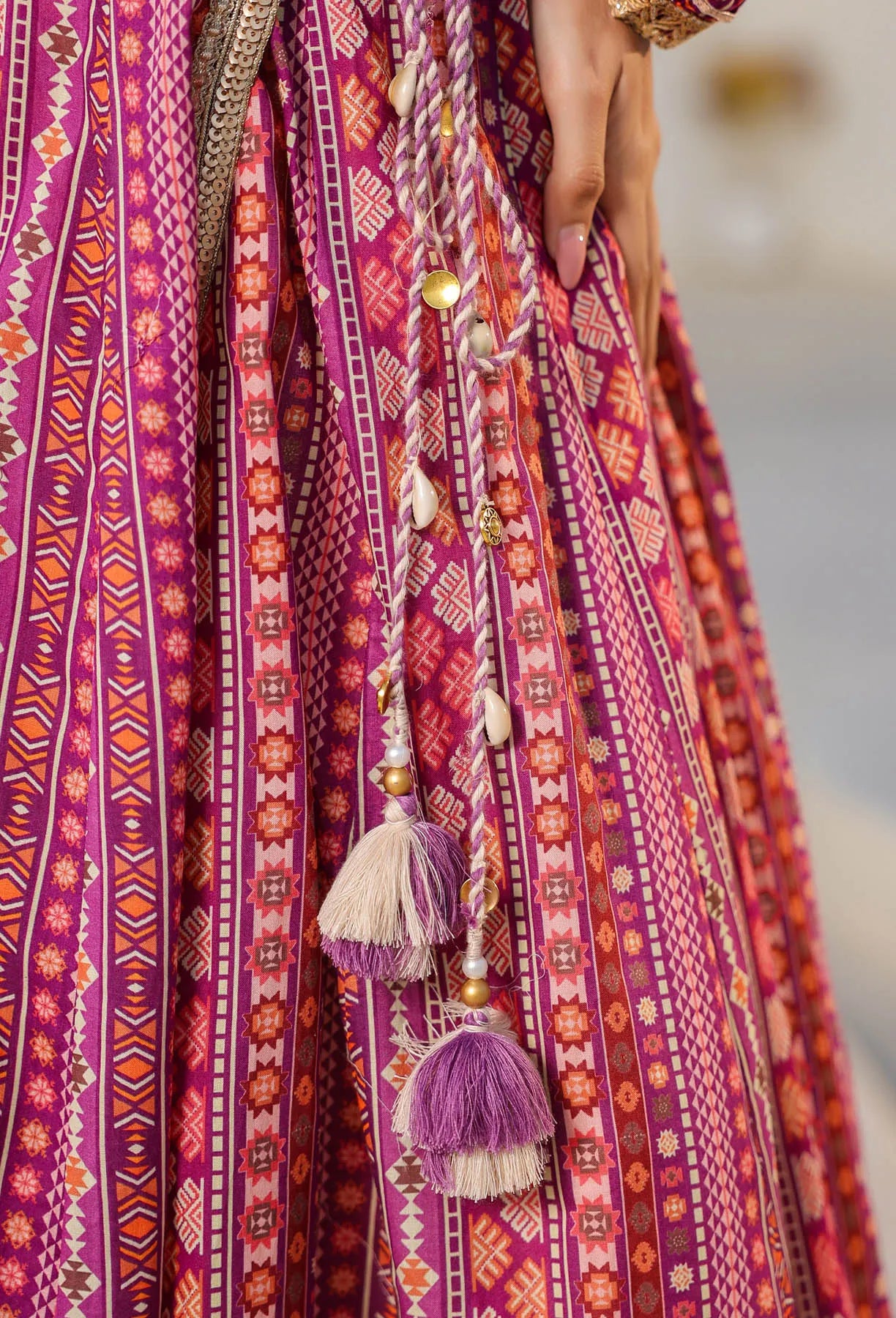 Close-up of a vibrant, patterned fabric with tassels and beads.