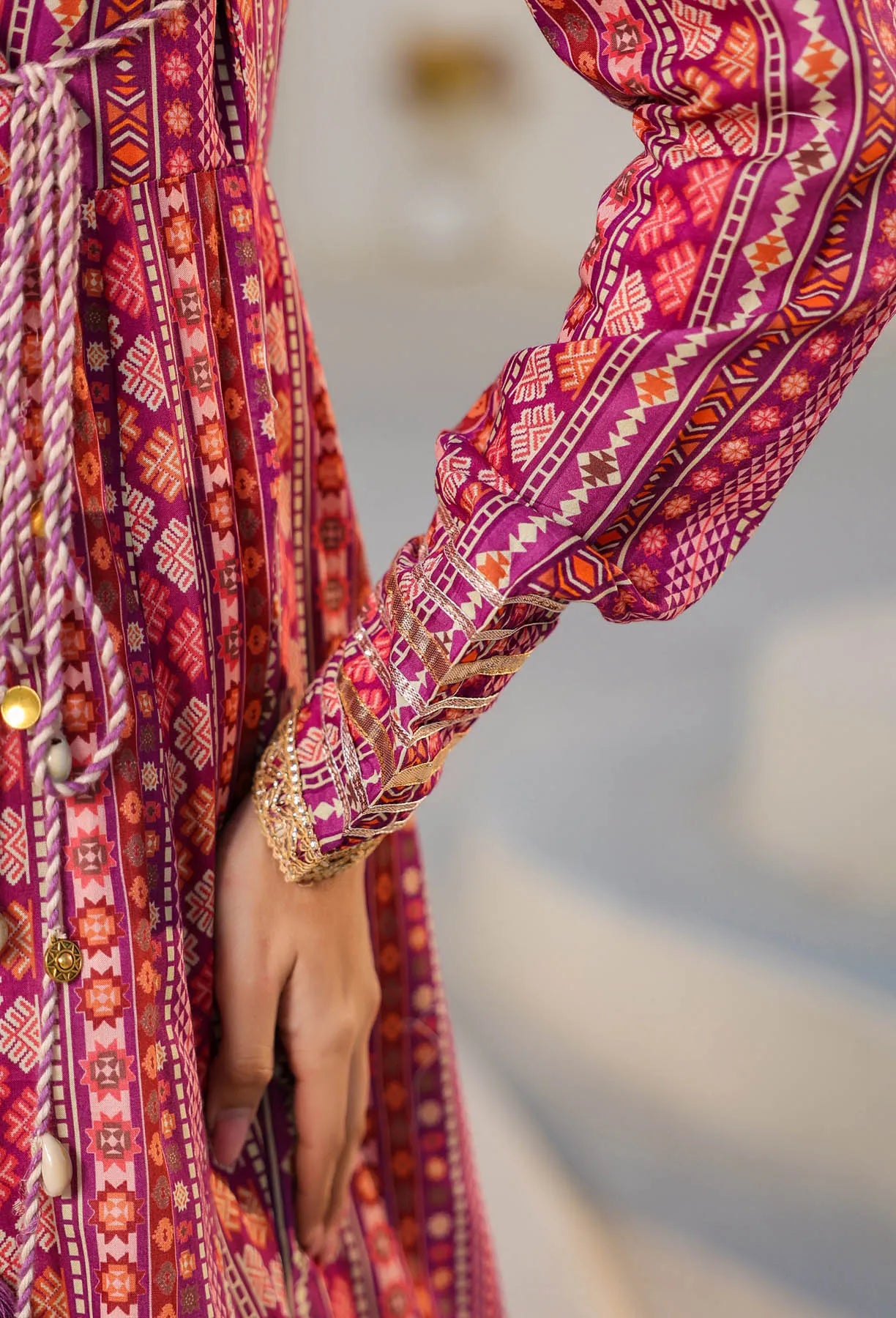 Close-up of a person wearing a vibrant, patterned dress with a blurred background