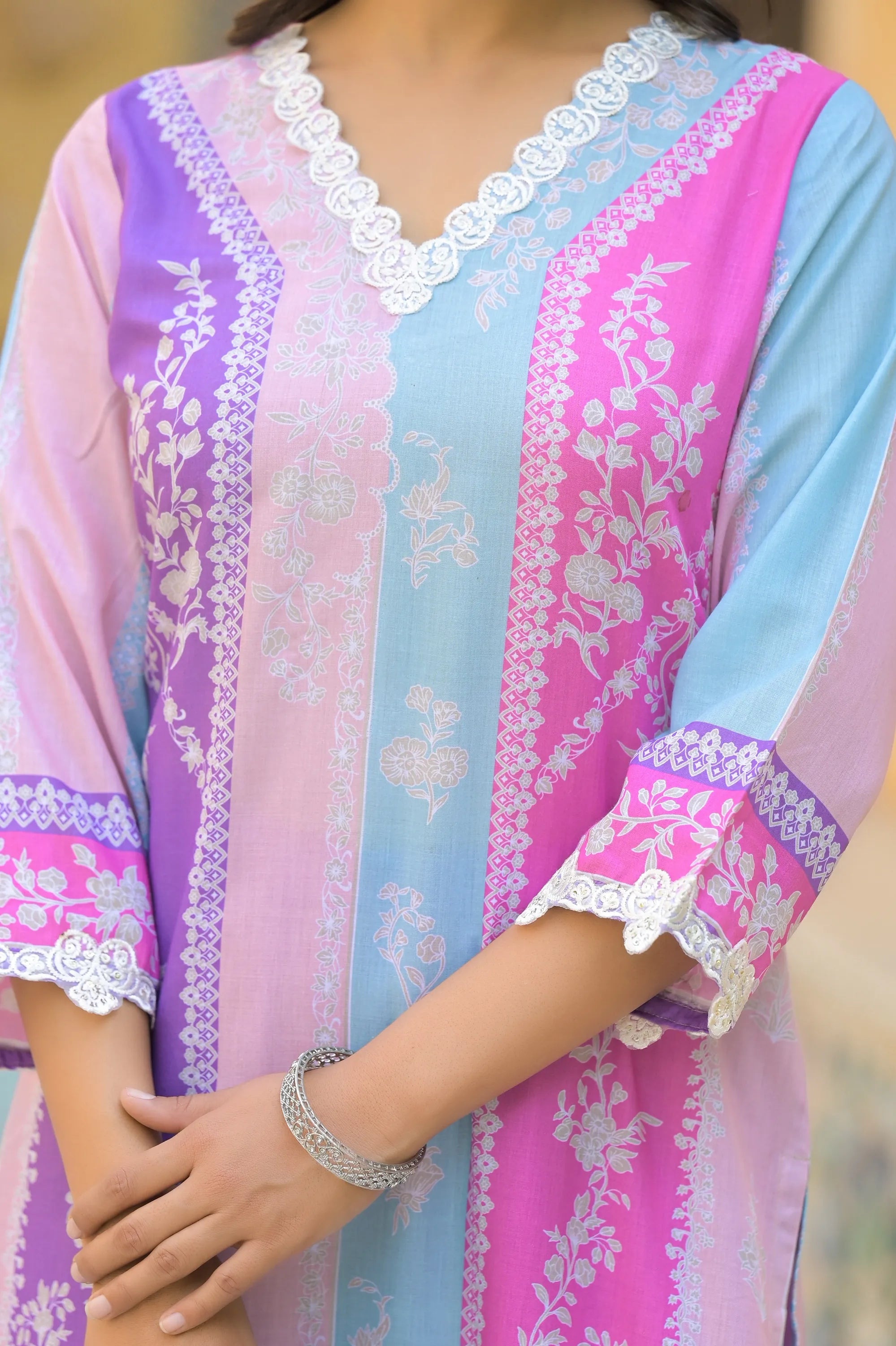 Colorful traditional outfit with floral patterns and lace details.