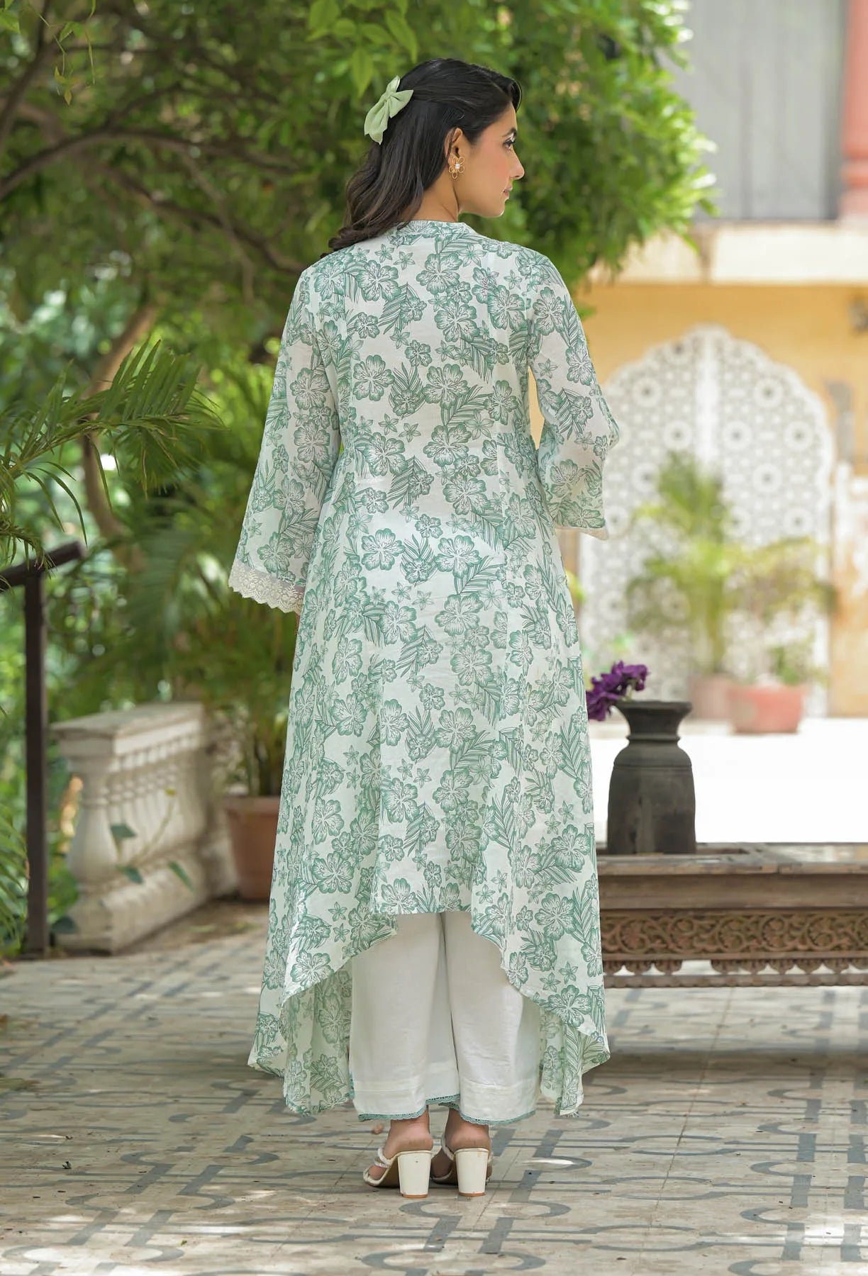 Woman wearing a light green floral dress in an outdoor setting
