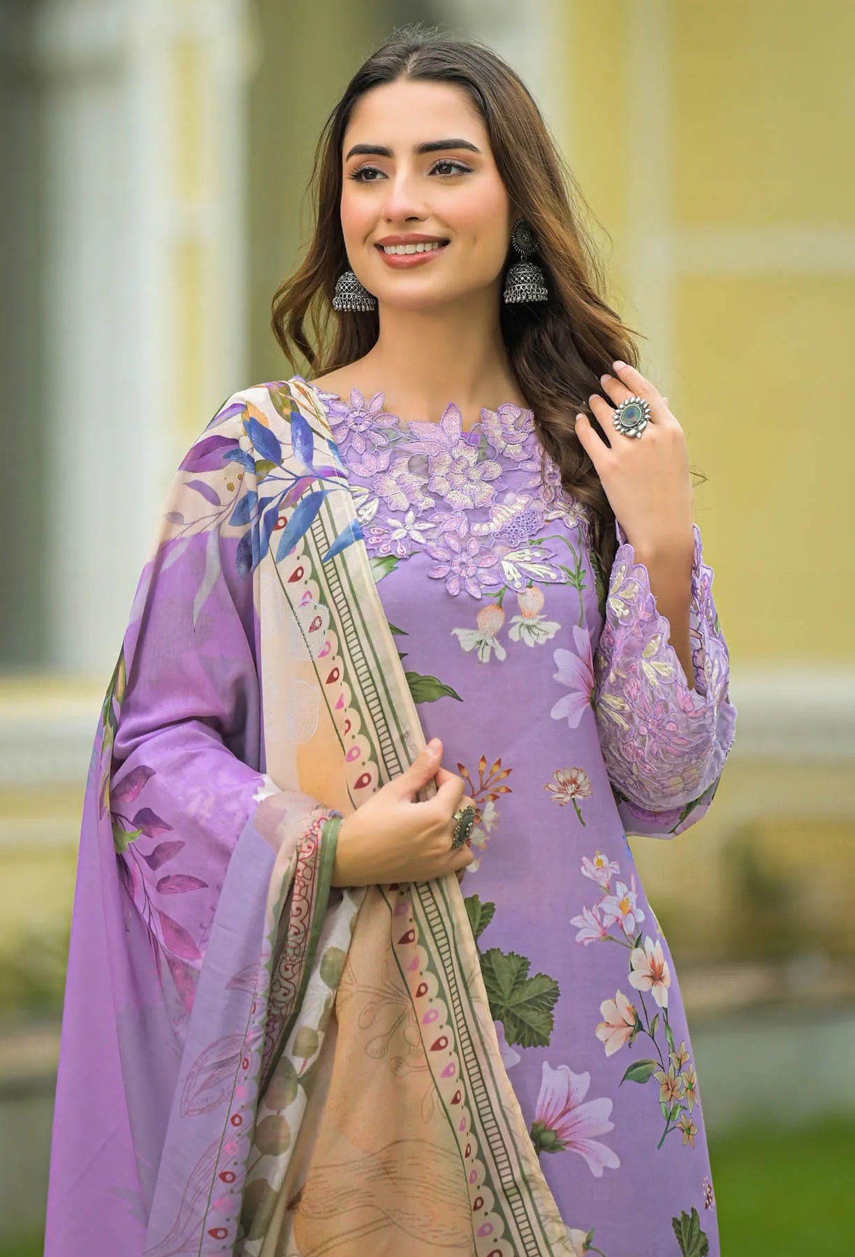 Woman wearing a purple floral dress with a matching dupatta in an outdoor setting
