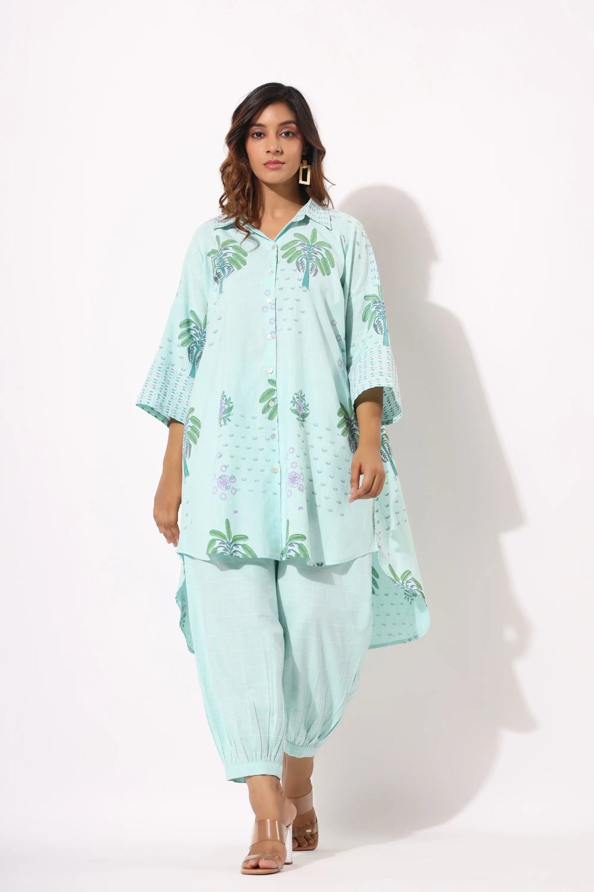 Woman wearing a light blue floral outfit on a white background