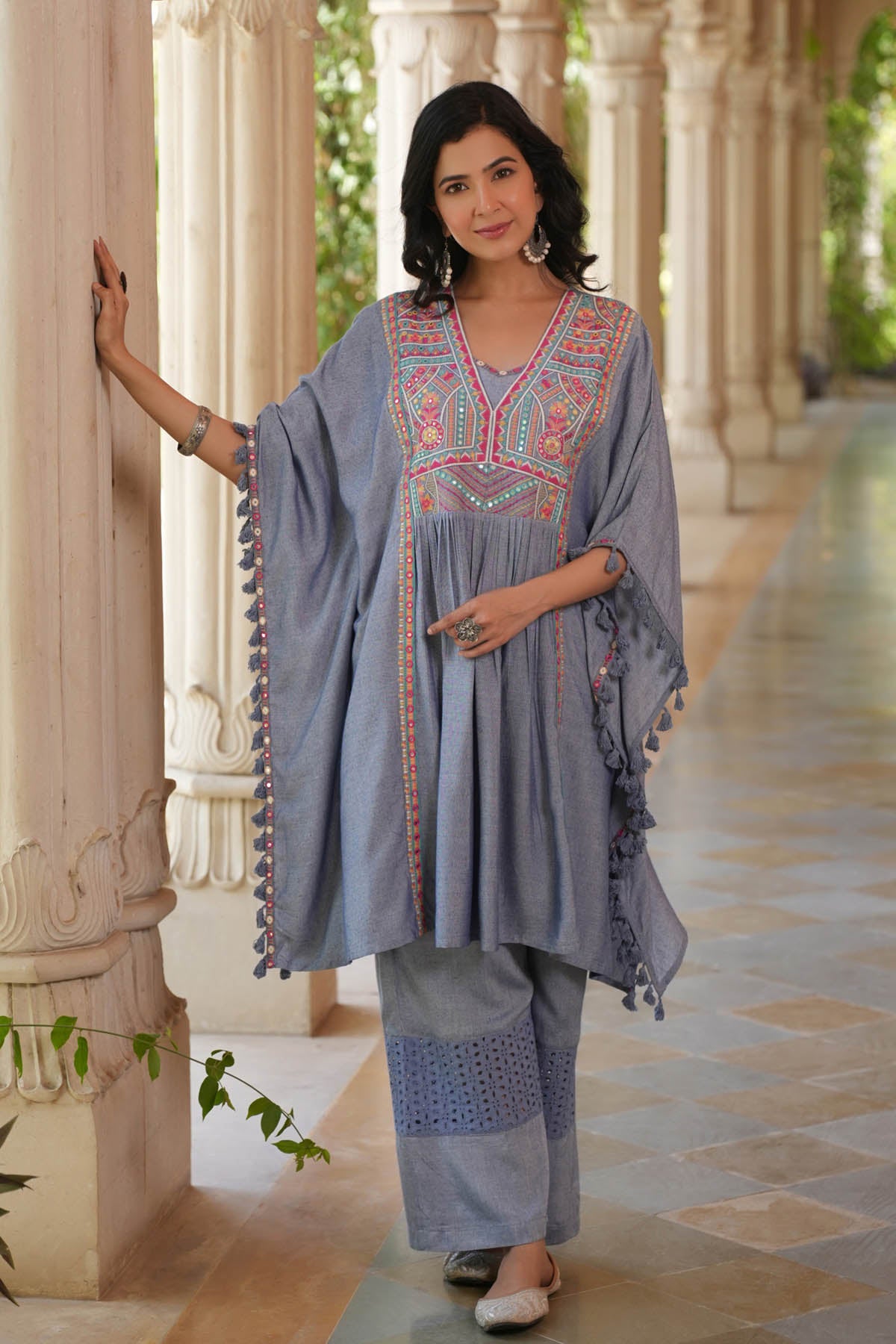Woman in traditional embroidered outfit standing in a decorative corridor