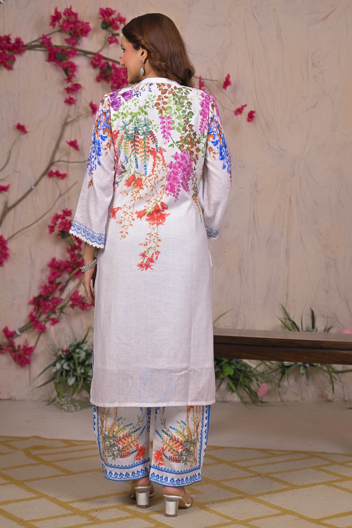 Woman wearing a colorful floral outfit with a decorative background