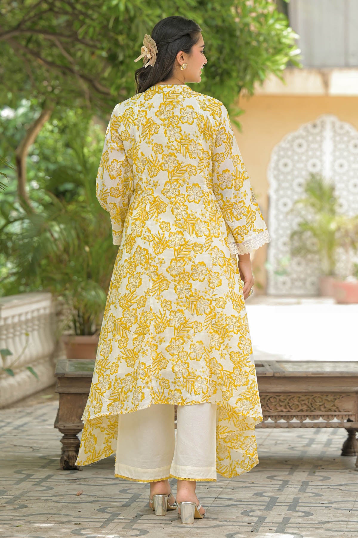 Woman wearing a yellow and white floral kurta in an outdoor setting