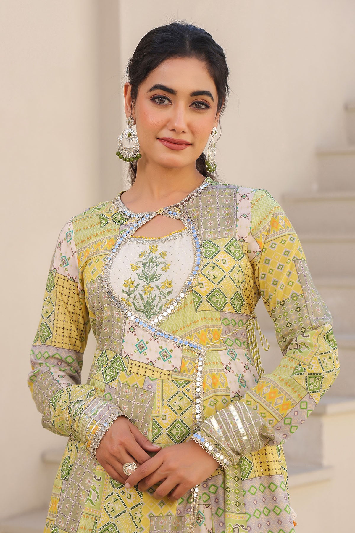 Woman wearing a traditional embroidered outfit with a neutral background
