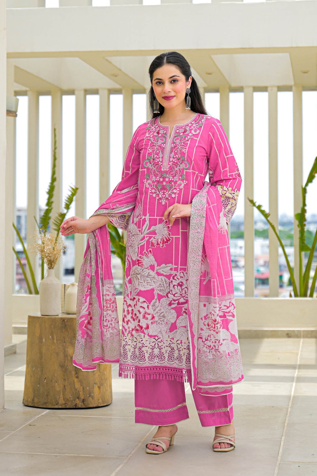 Woman wearing a pink embroidered traditional outfit with a white background