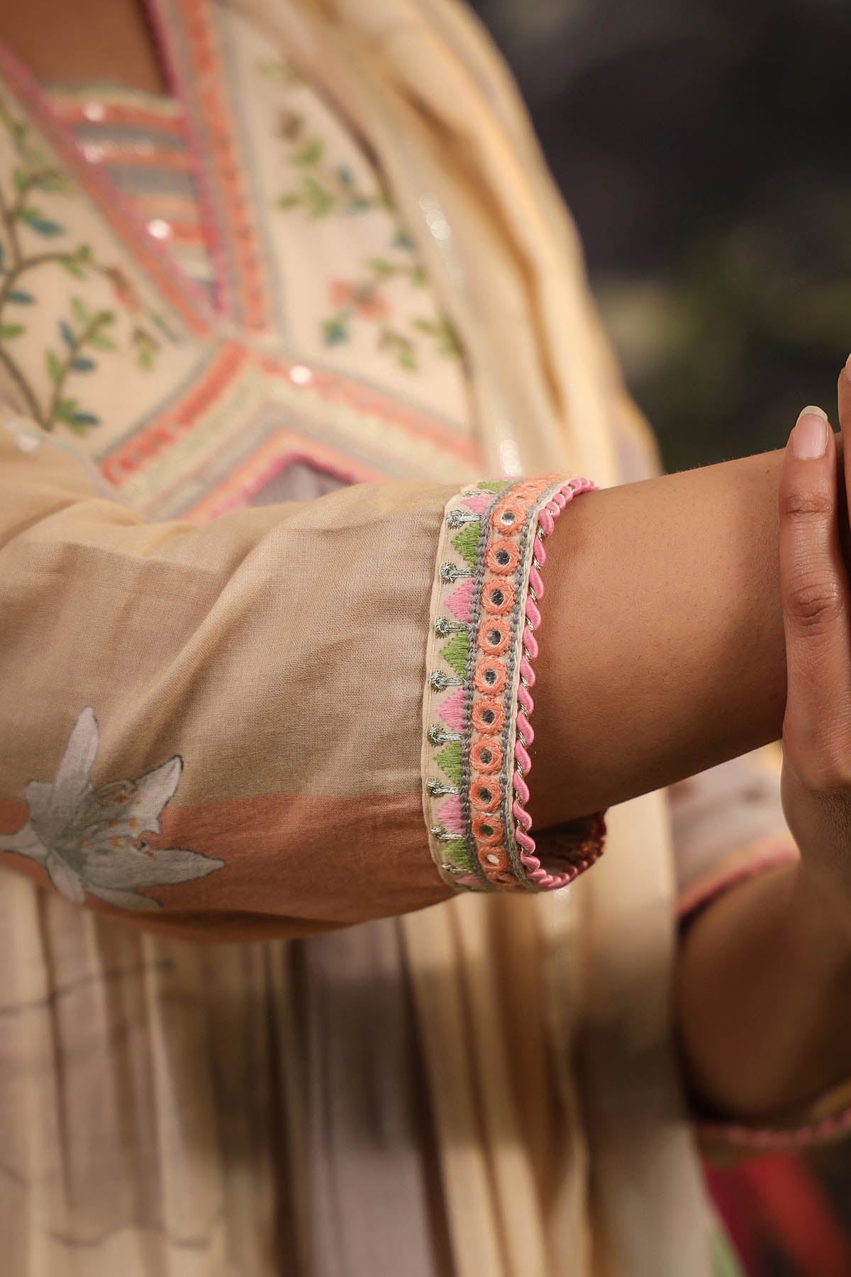 Close-up of a person's arm wearing colorful bracelets with a blurred background