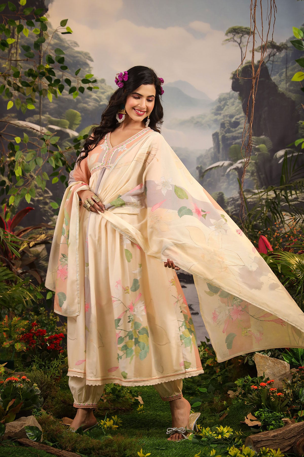 Woman in a traditional outfit standing in a lush, natural setting