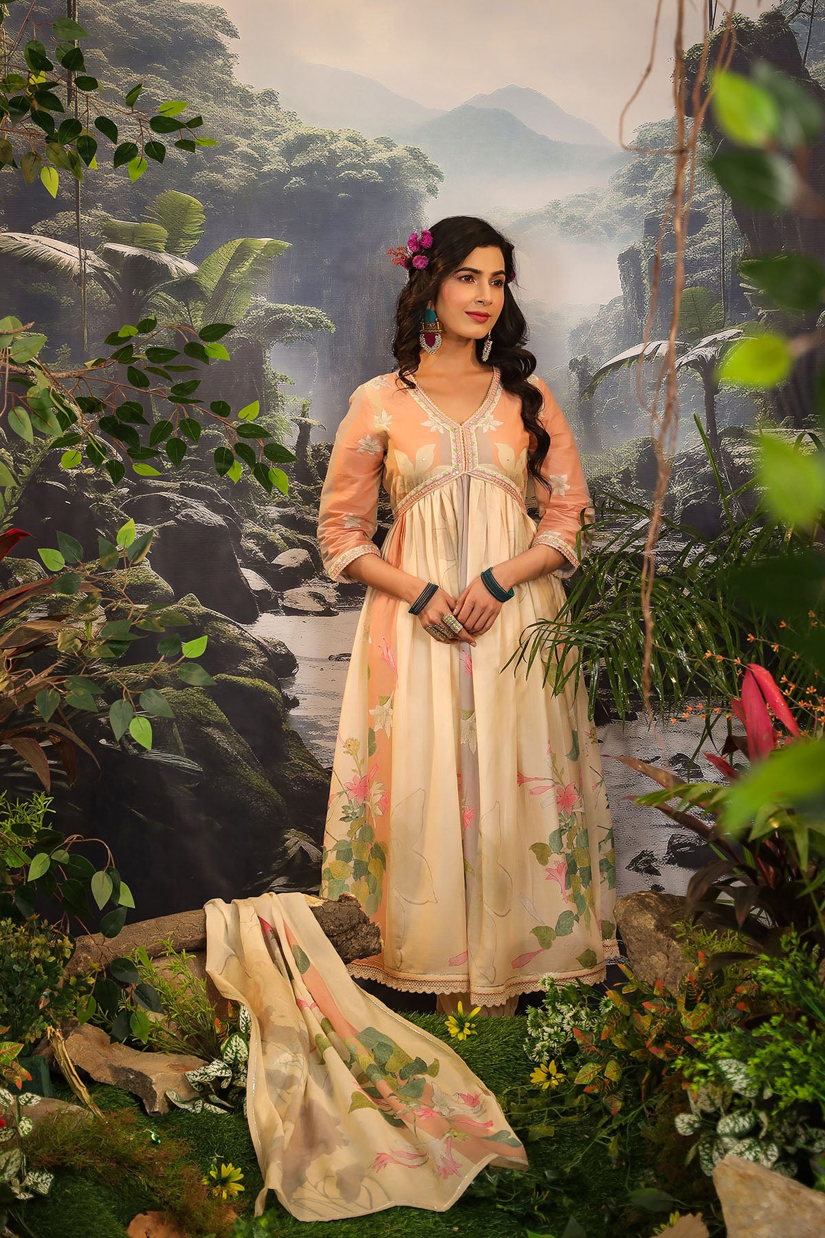 Woman in a traditional outfit standing in a lush, green forest setting