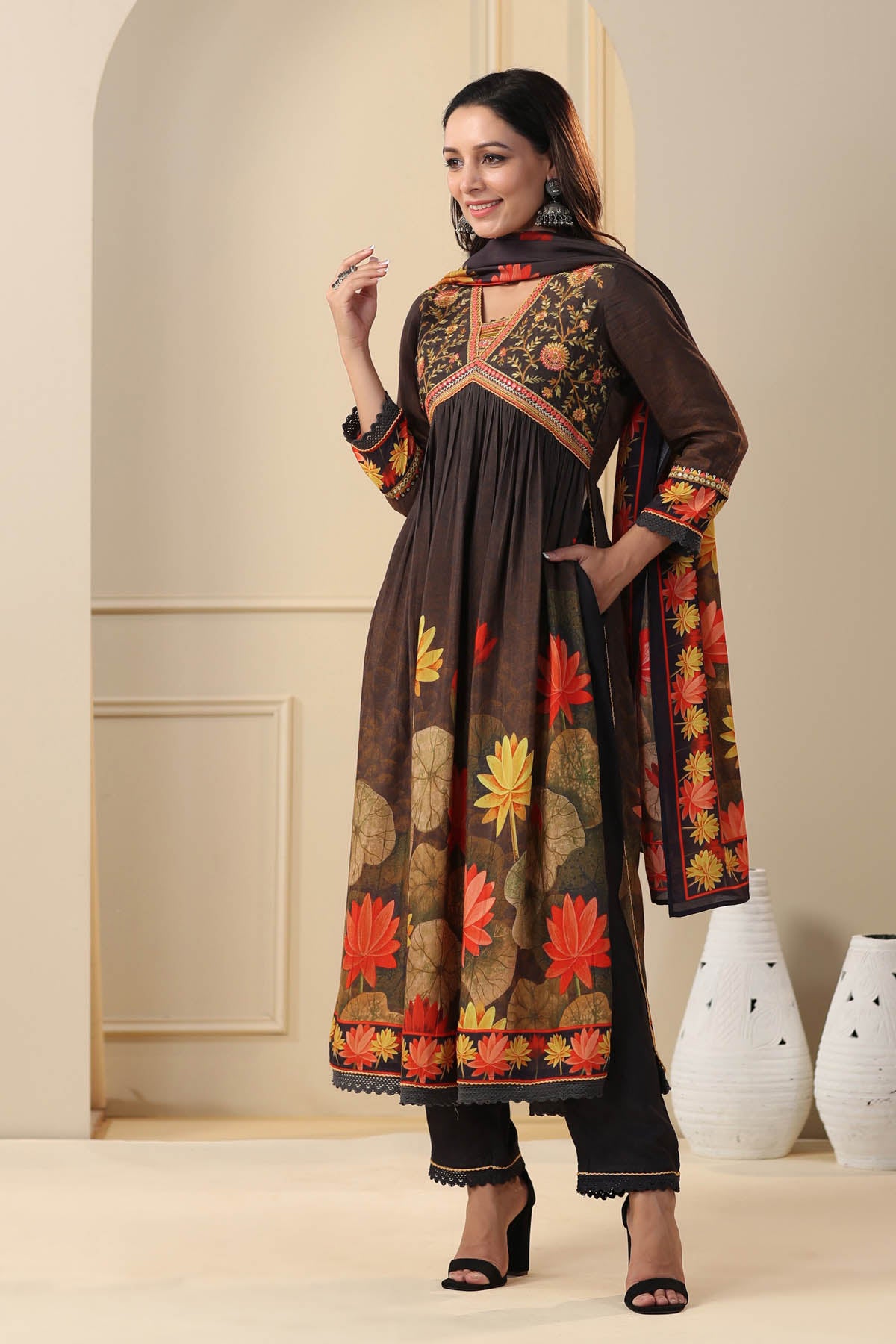 Woman wearing a traditional outfit with floral patterns in a minimalistic setting
