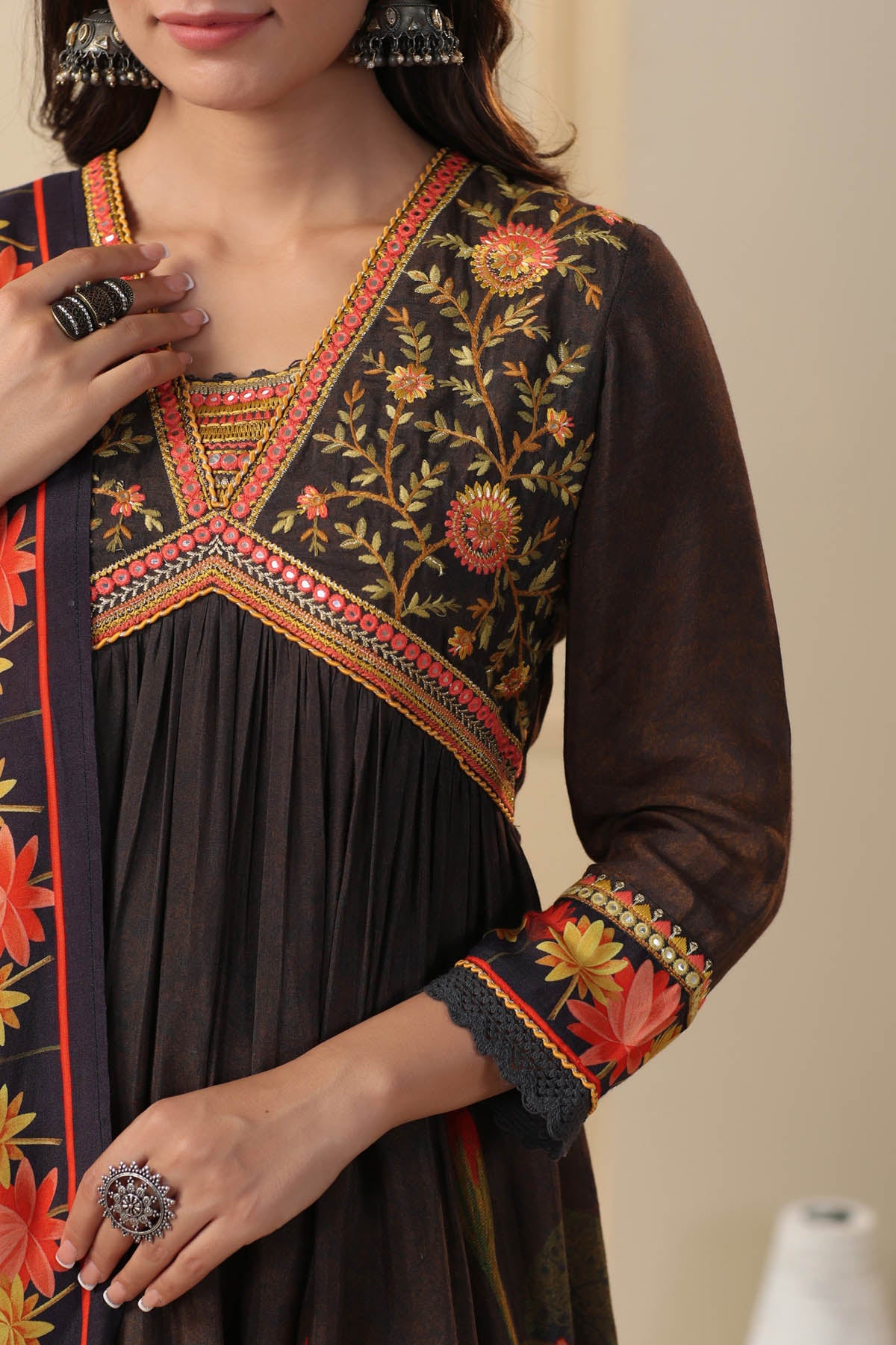 Traditional embroidered dress with intricate patterns on a neutral background
