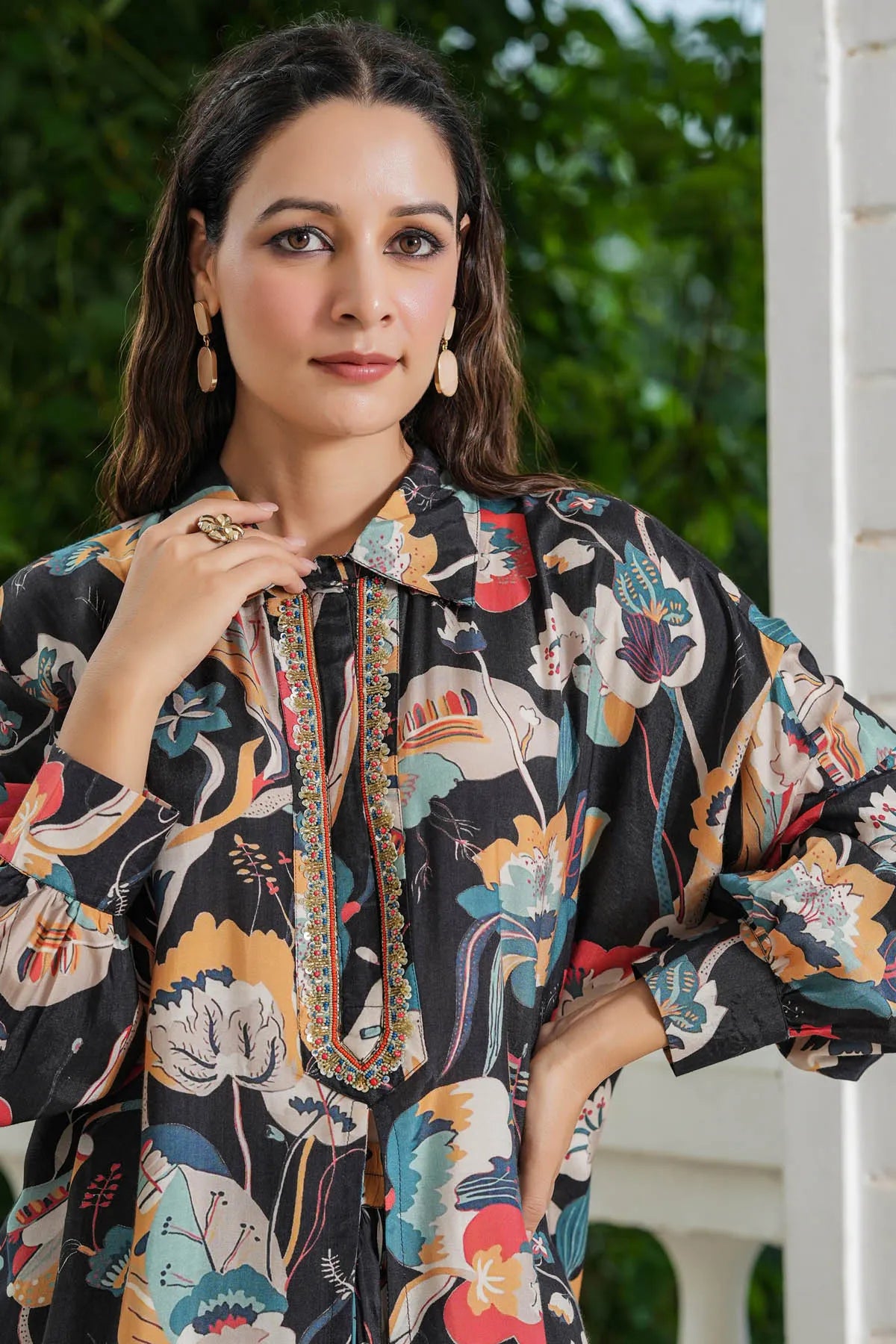 Woman wearing a floral patterned outfit with a blurred green background