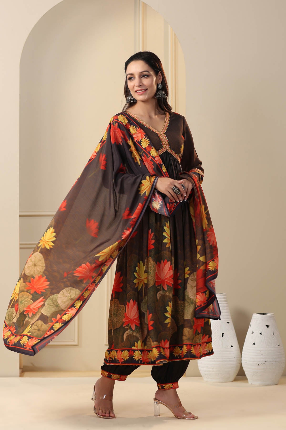 Woman wearing a floral dress with a shawl in a minimalistic setting
