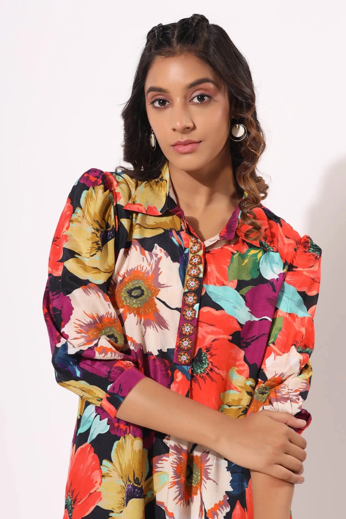 Woman wearing a colorful floral dress with a white background