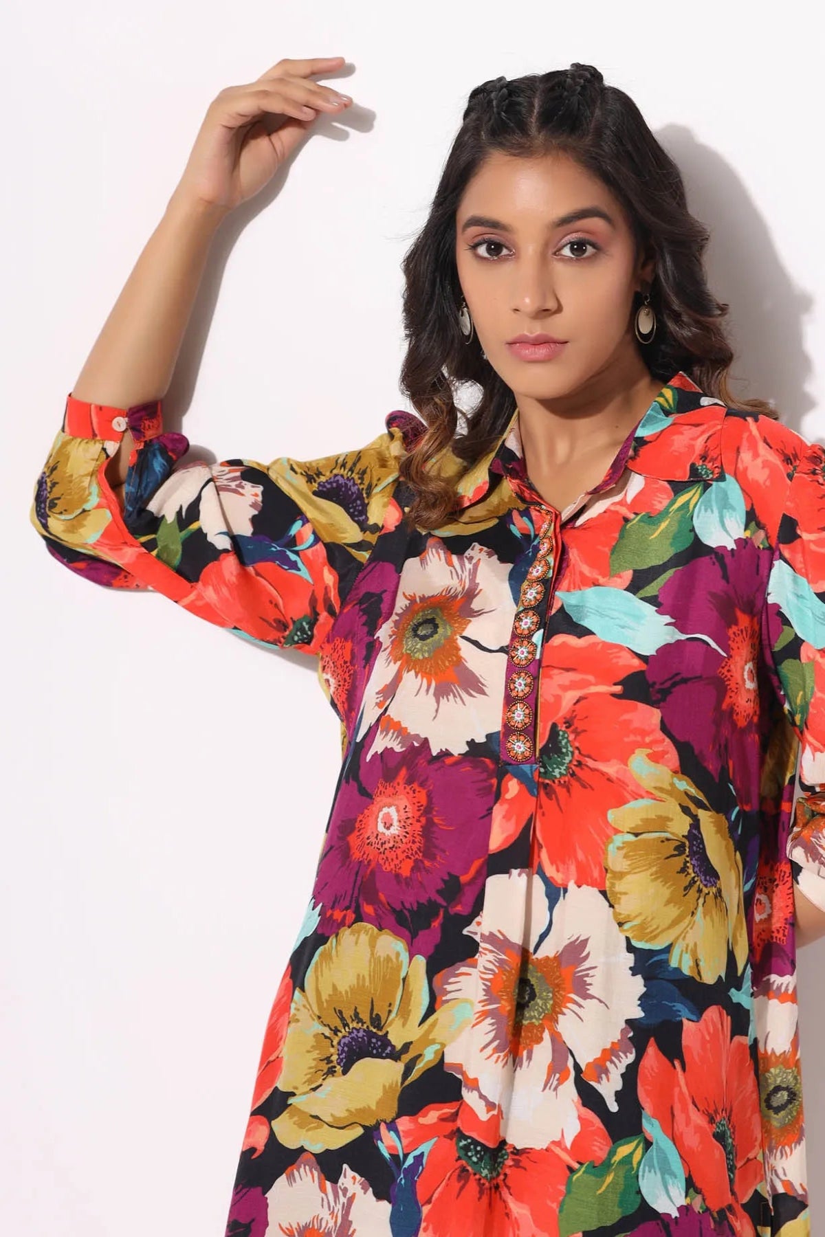 Woman wearing a colorful floral dress against a white background