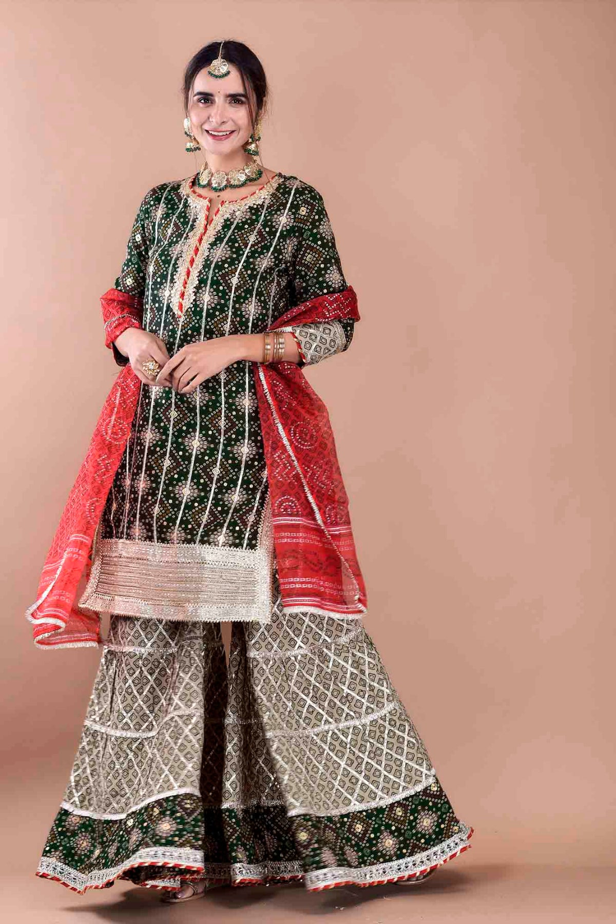 Woman wearing a traditional outfit with a red and green pattern on a beige background