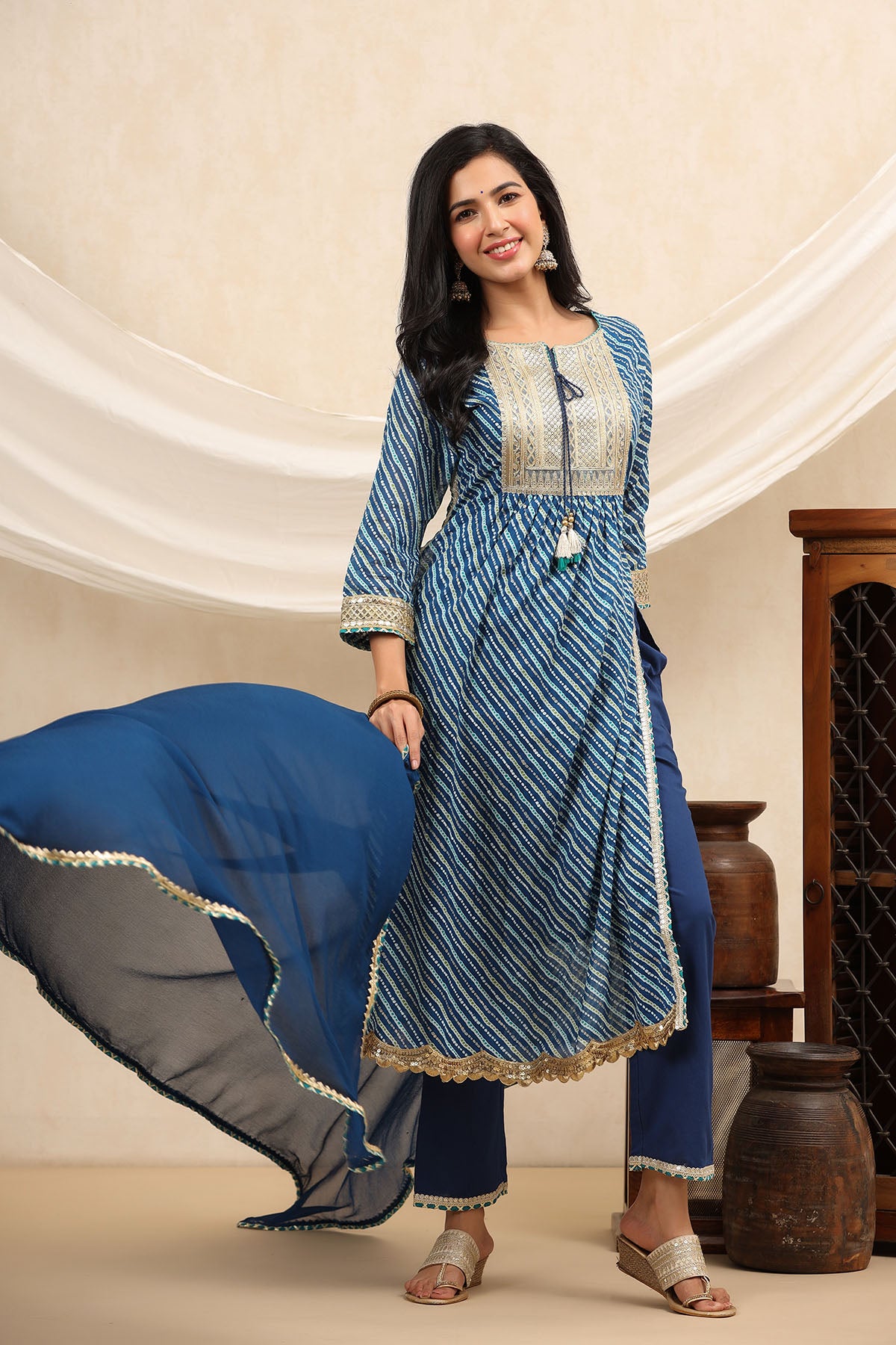 Woman wearing a blue and white traditional outfit with a beige background