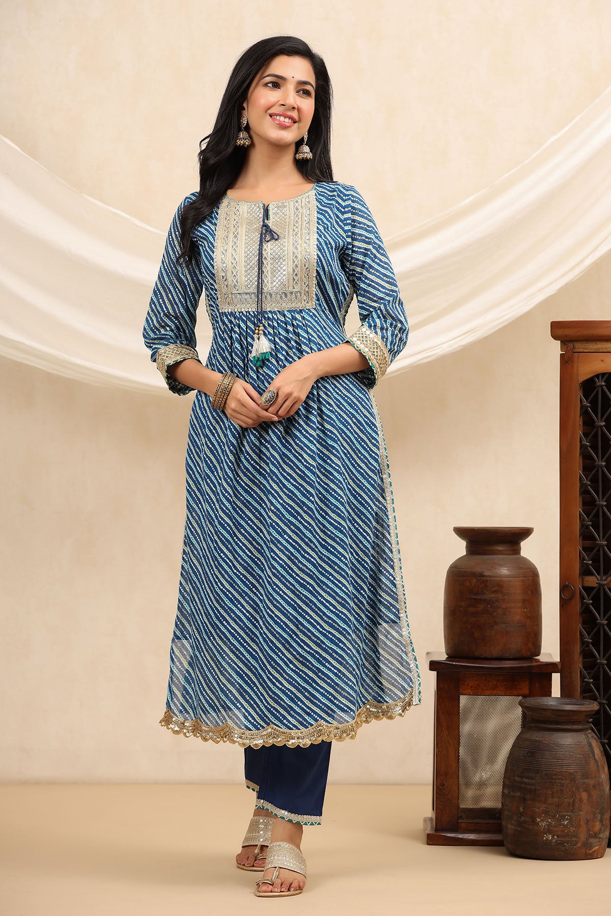 Woman wearing a blue and white patterned kurta with a beige background