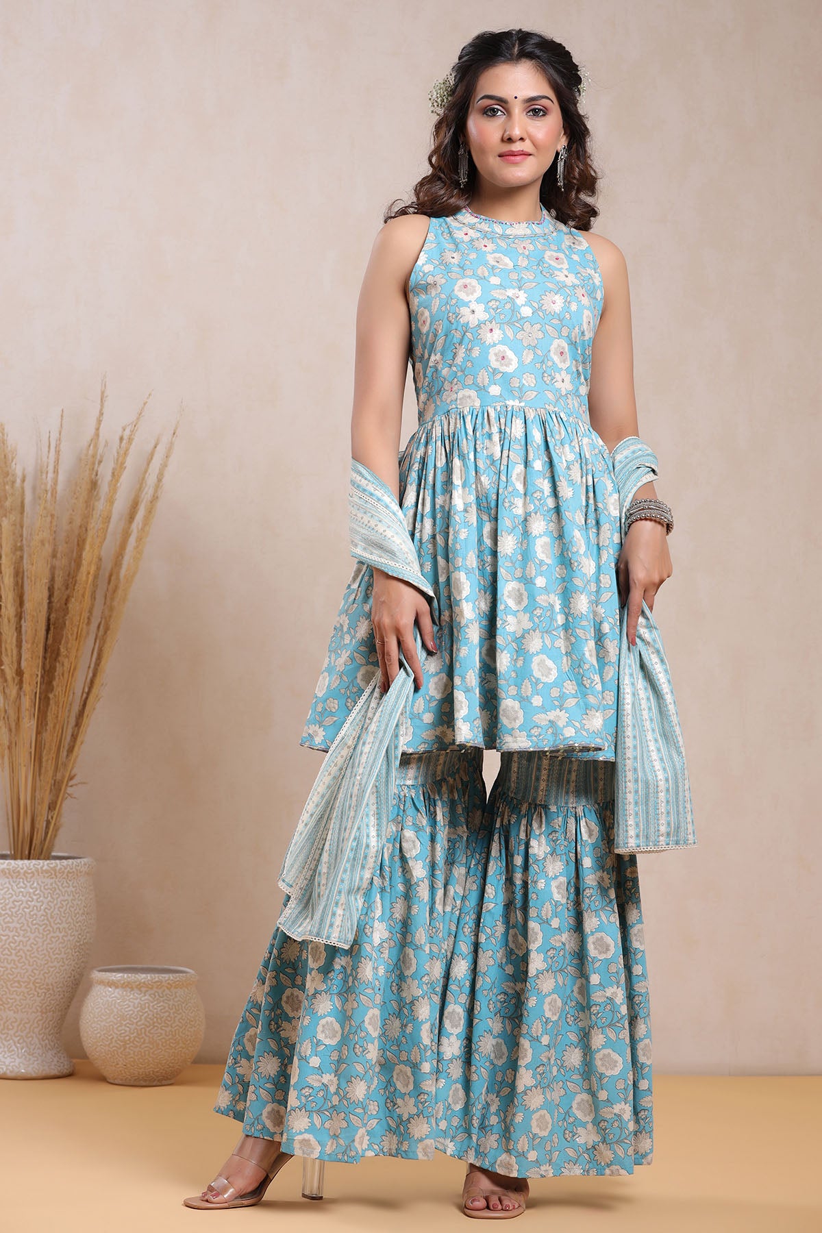 Woman wearing a blue floral dress with a beige background