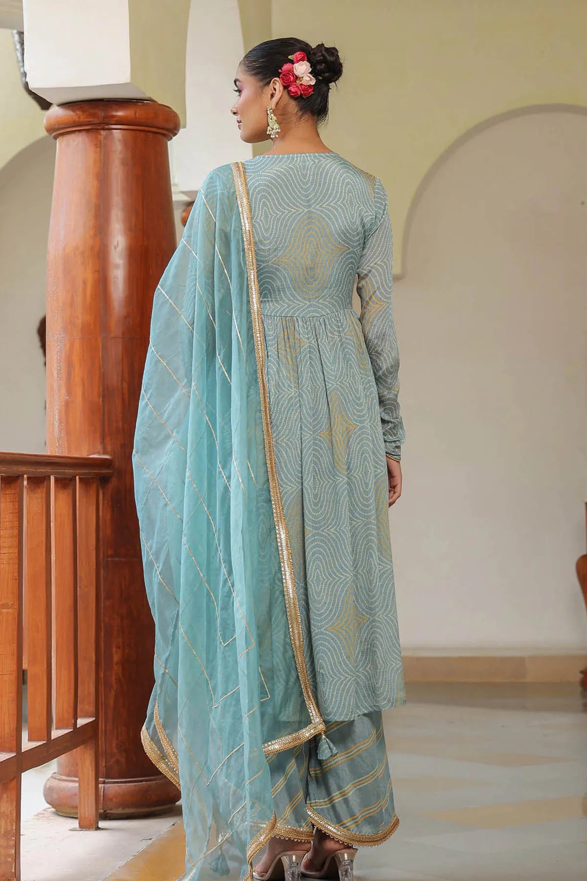 Woman in a light blue traditional outfit with a matching dupatta in an indoor setting.