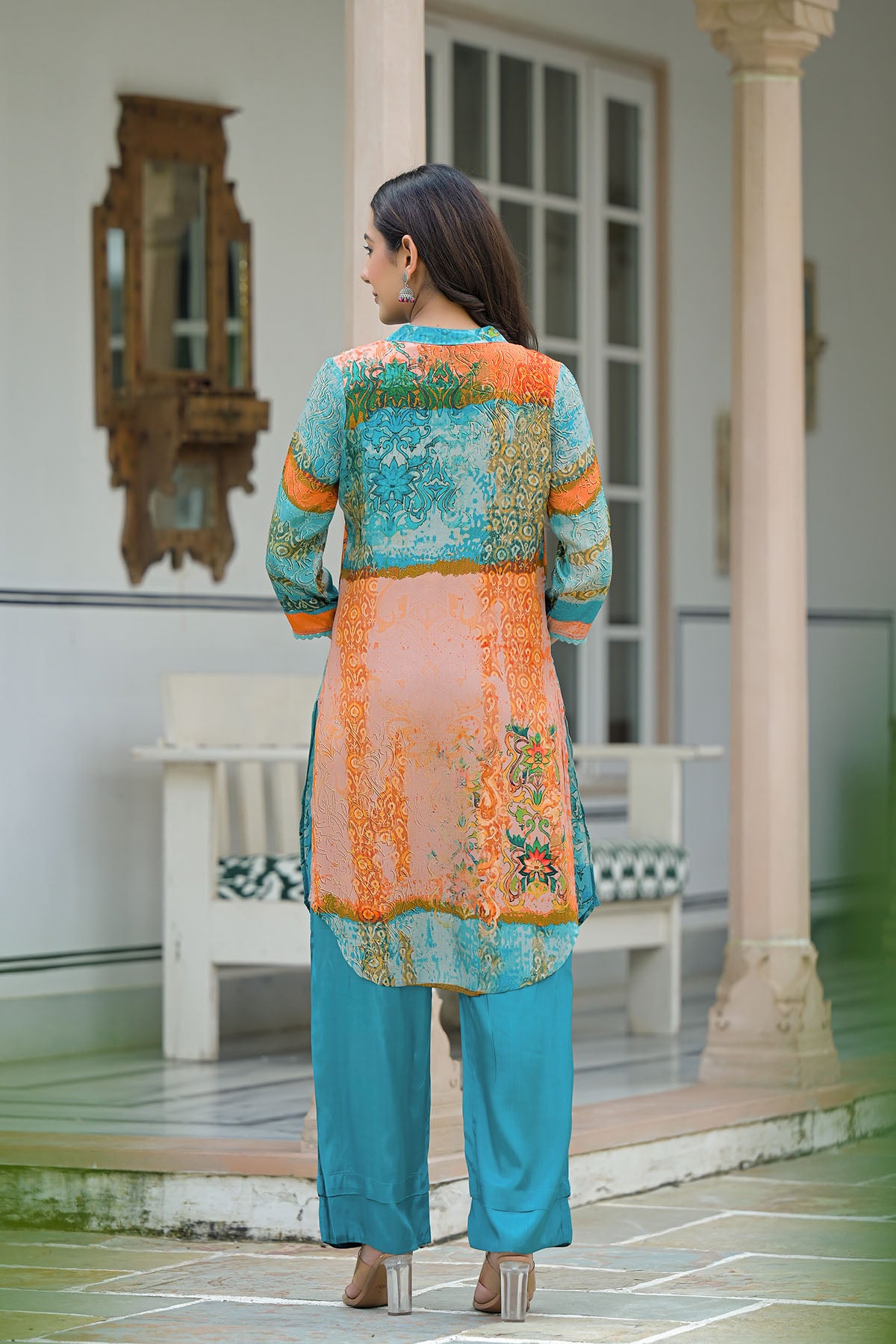 Woman wearing a colorful traditional outfit in an outdoor setting.