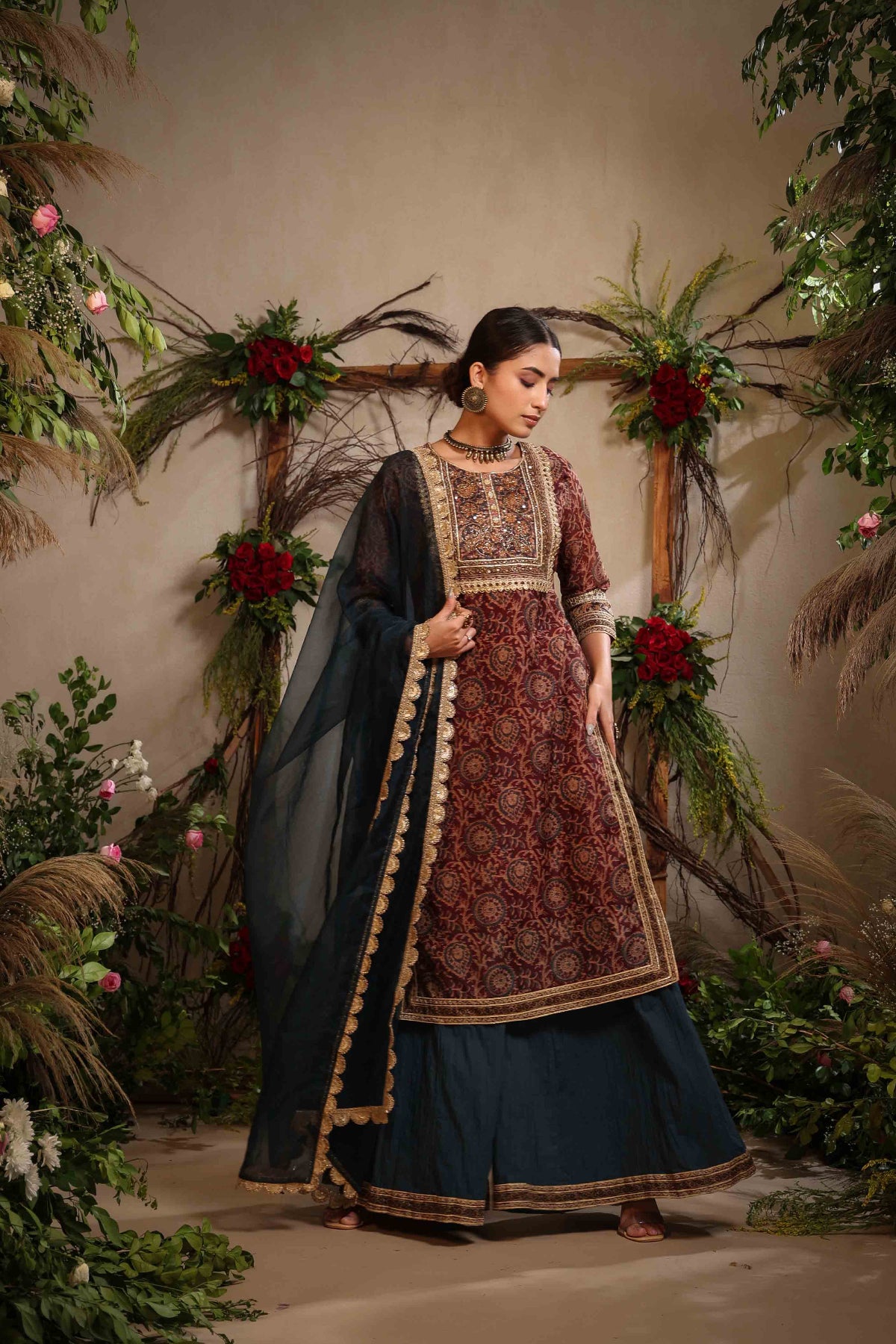 Woman in traditional outfit with floral decorations in the background