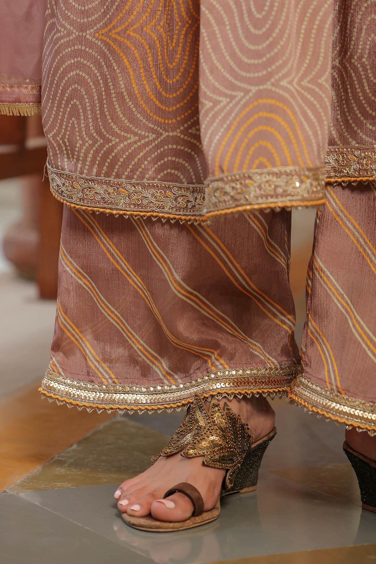 Traditional outfit with gold embroidery on a reflective surface