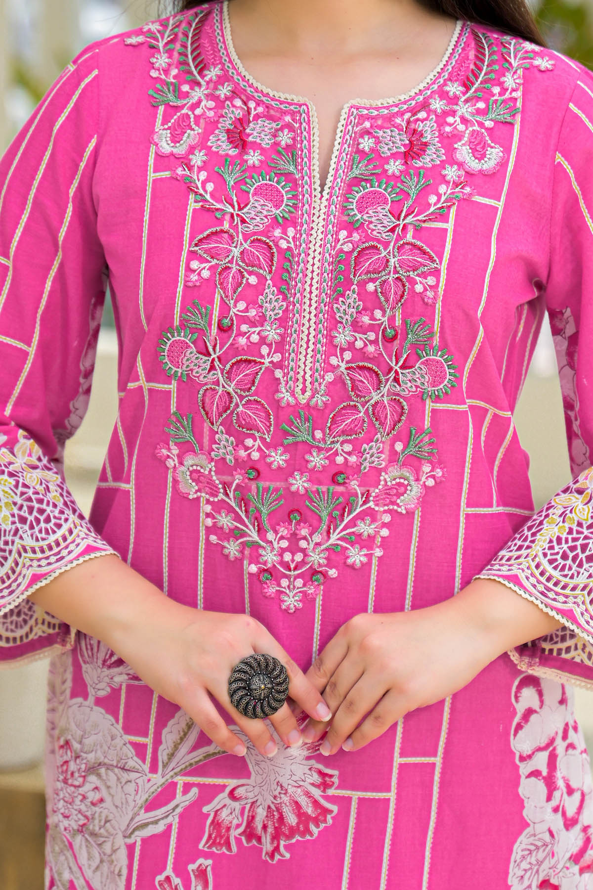 Close-up of a pink embroidered garment with intricate patterns.