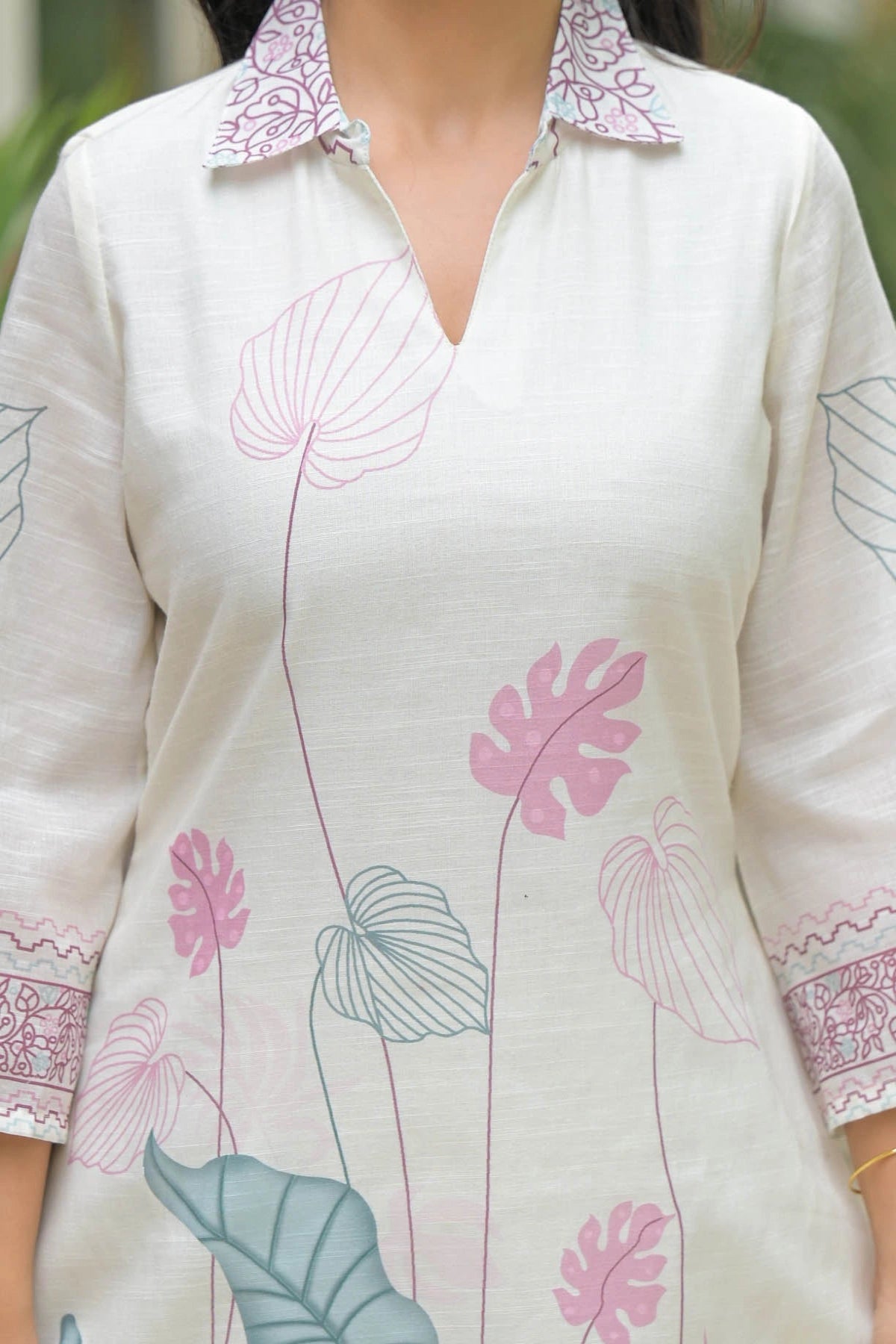 White shirt with pink and blue floral patterns worn by a person