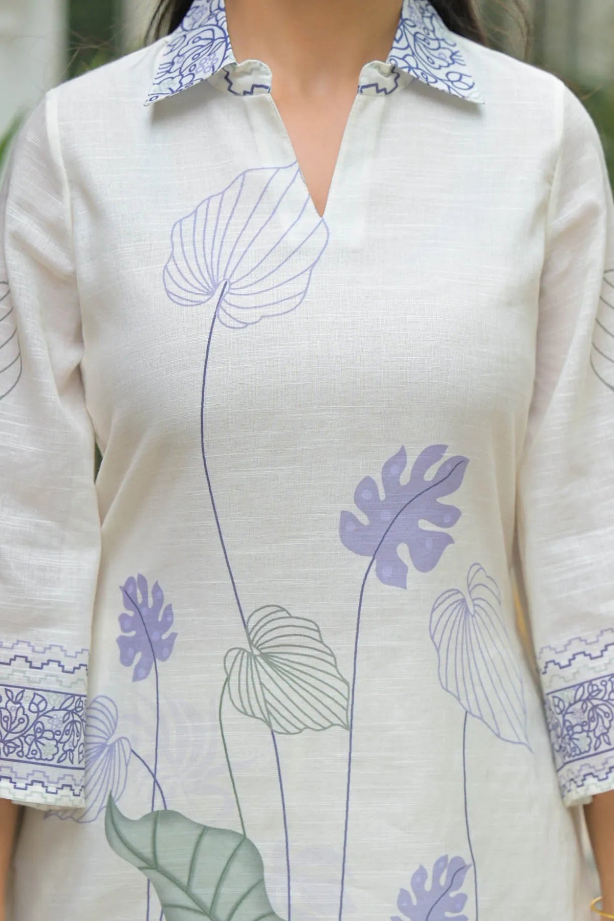 White shirt with blue floral embroidery on a blurred background