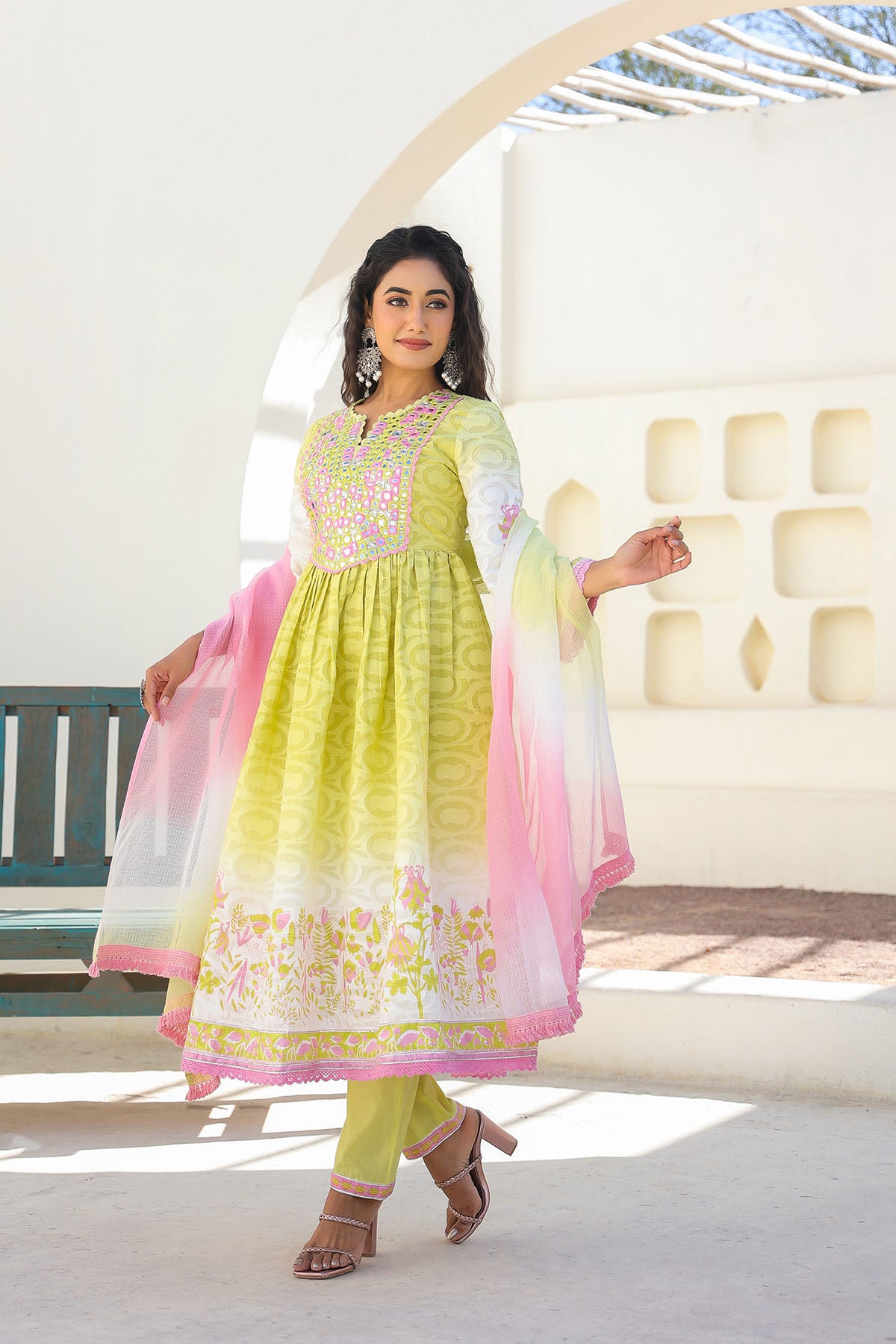 Woman wearing a green and pink traditional outfit with a white background