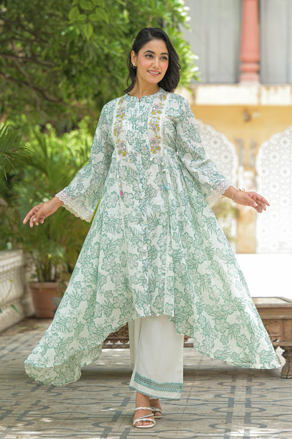 Woman wearing a light green floral kurta with white pants outdoors.