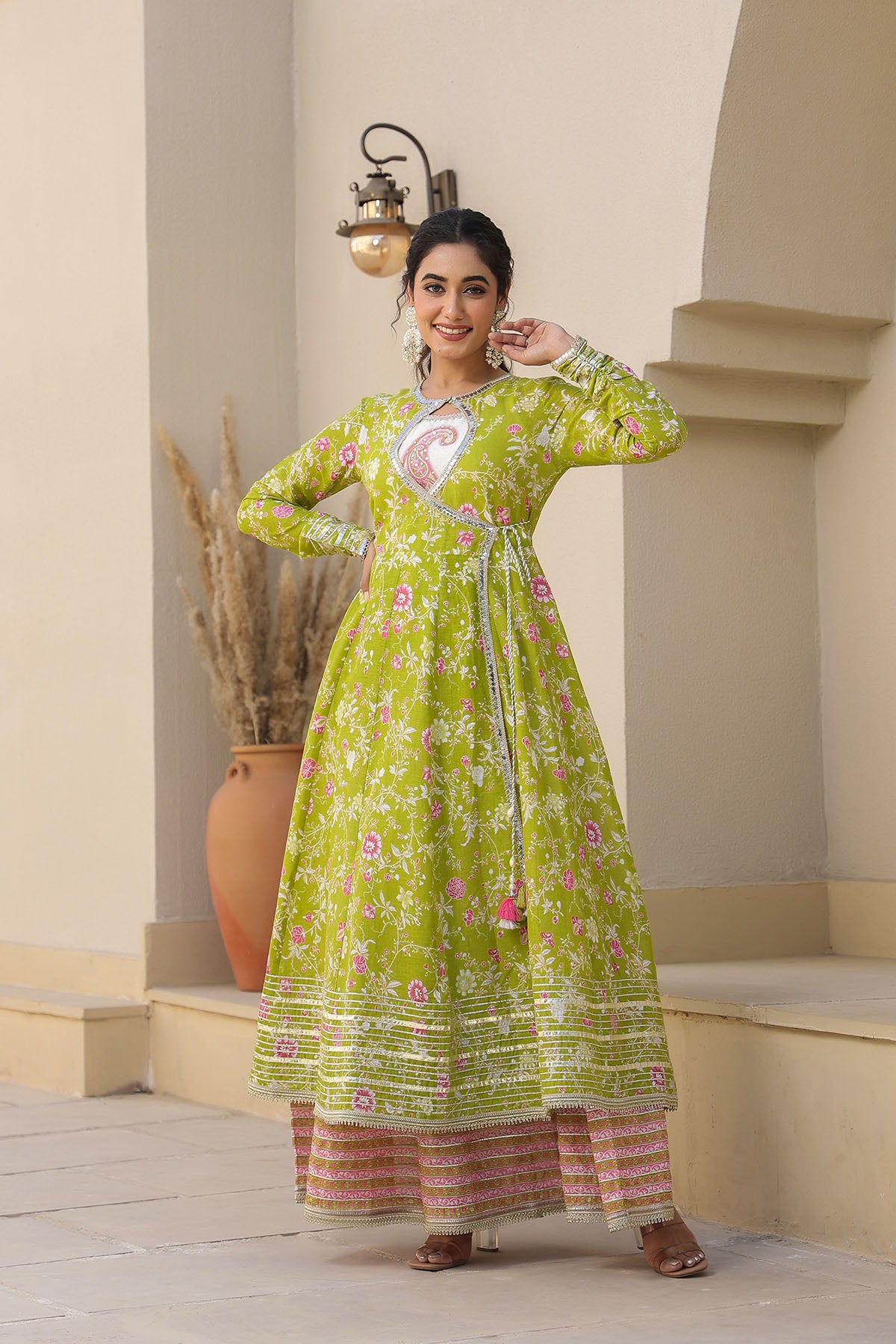 Woman wearing a green floral dress standing in an outdoor setting.
