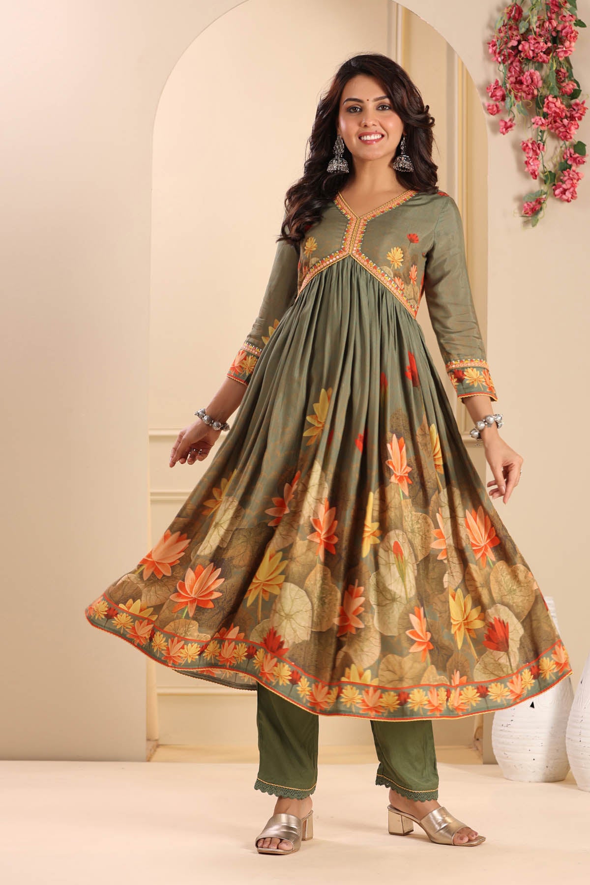 Woman wearing a green floral dress with a neutral background