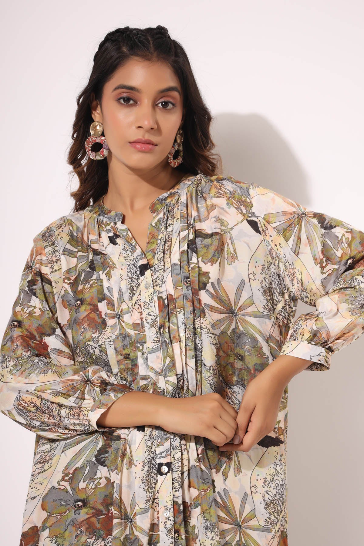Woman wearing a floral patterned outfit against a plain background