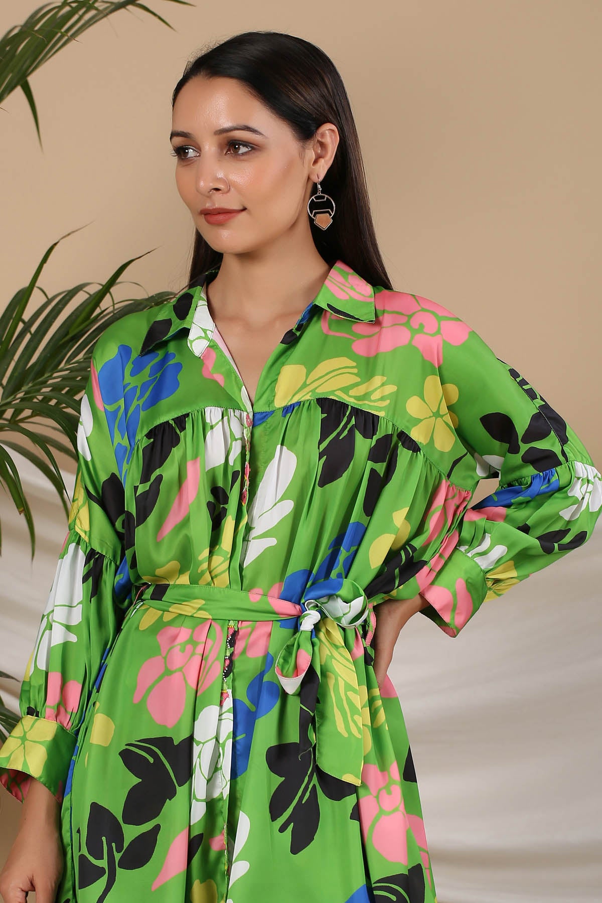 Woman wearing a colorful floral dress with a neutral background