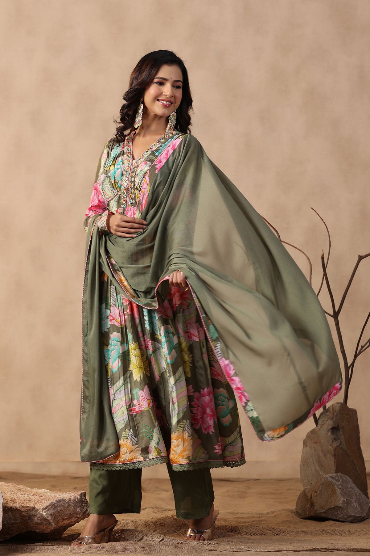Woman in a traditional outfit with a floral design against a beige background