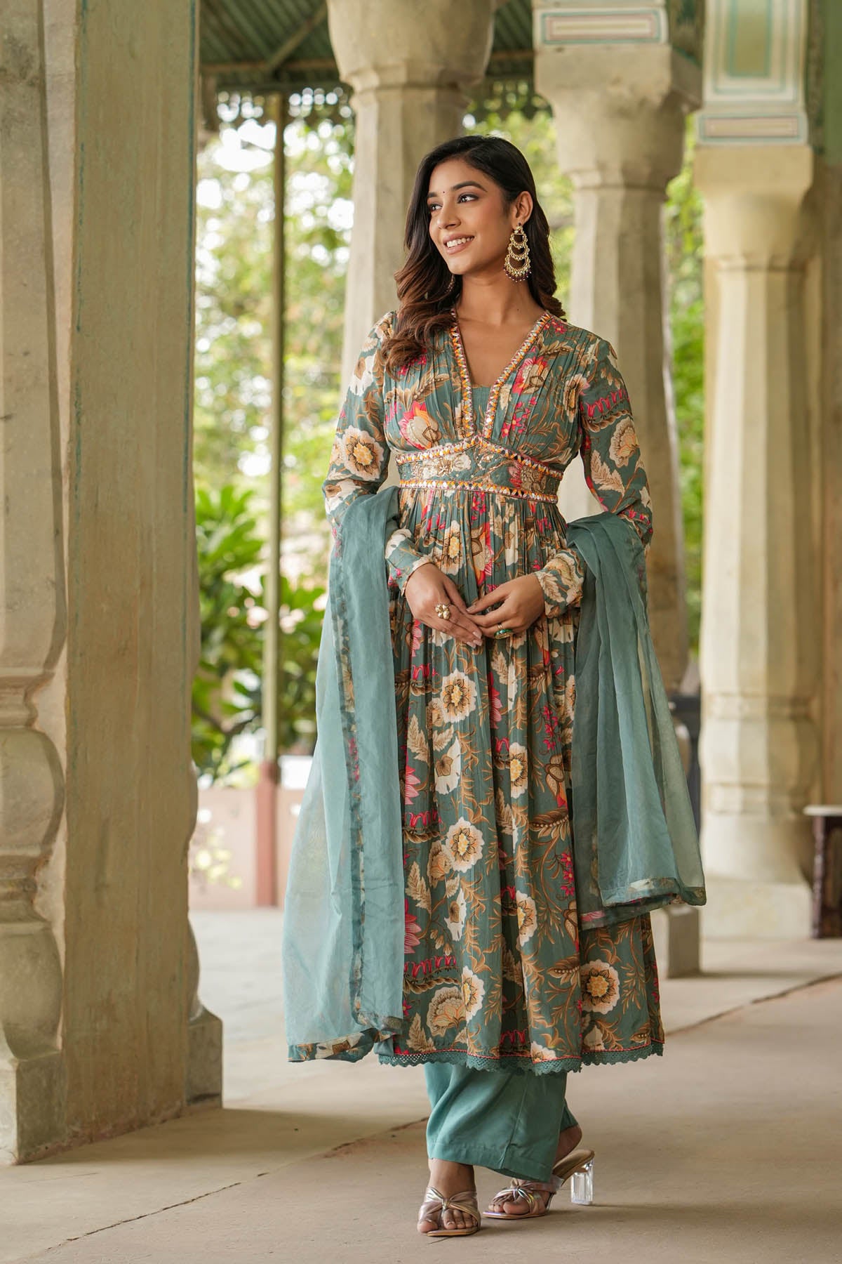 Woman in traditional outfit standing in a decorative outdoor setting