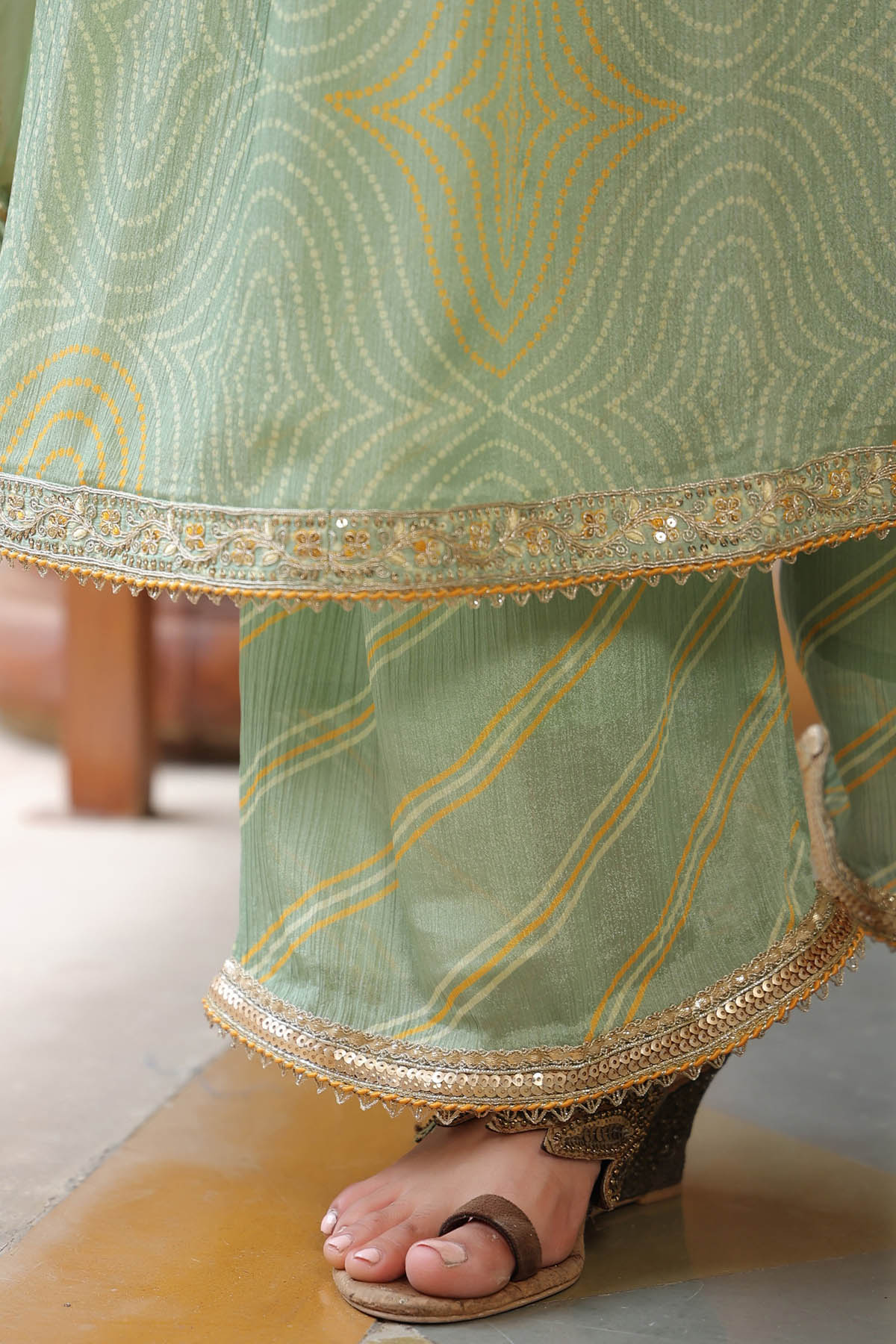 Green traditional outfit with gold embroidery on a blurred background