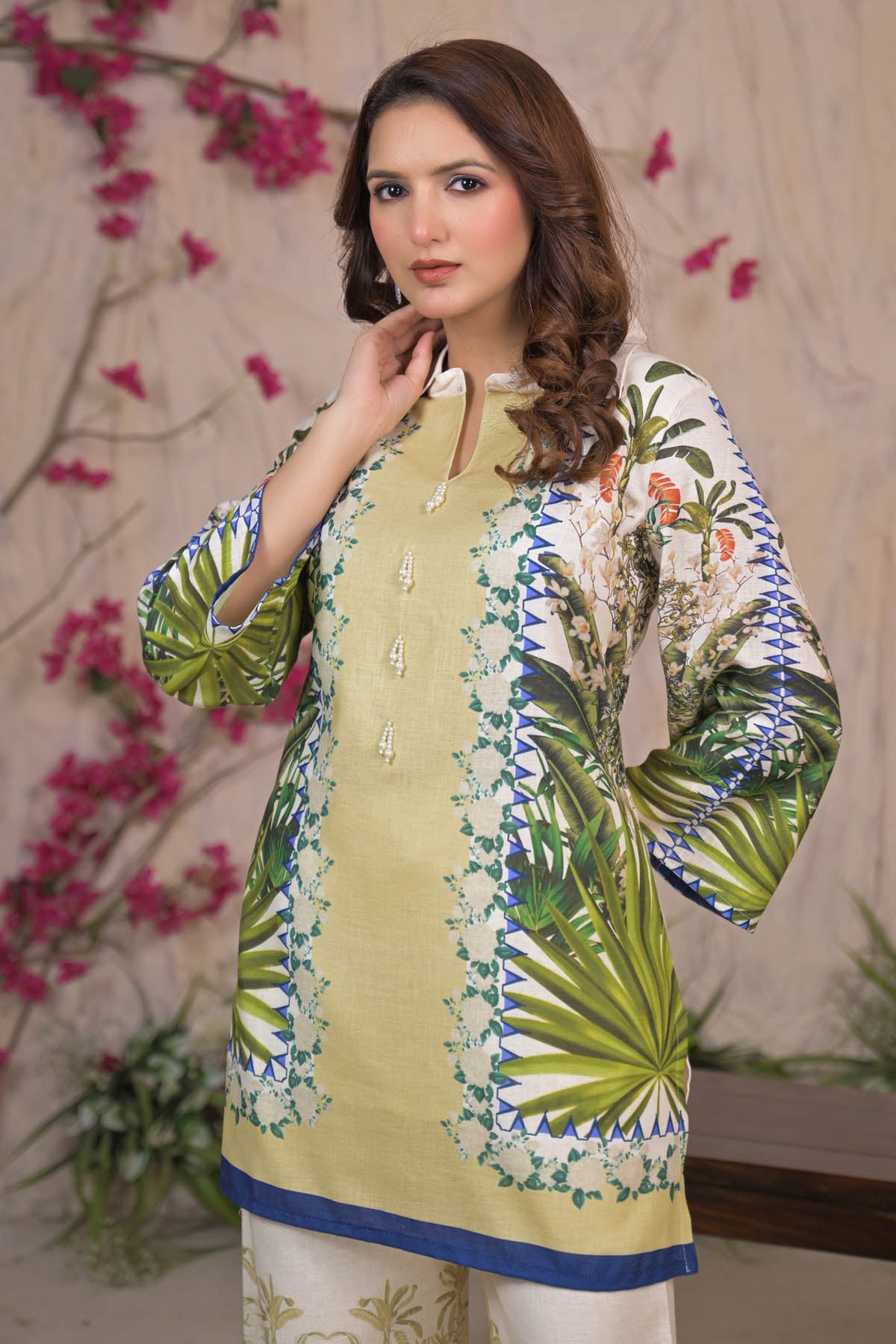 Woman wearing a green and white embroidered kurta with a floral background